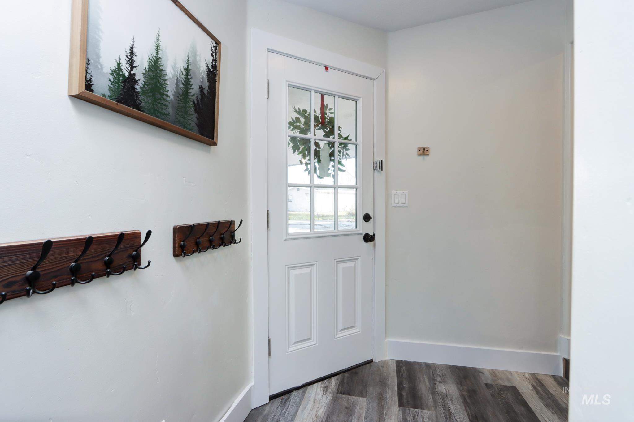 Entryway with wood finished floors and baseboards