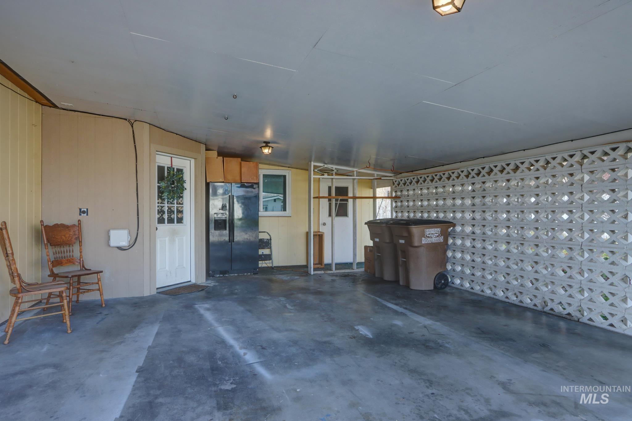 Garage with black refrigerator with ice dispenser