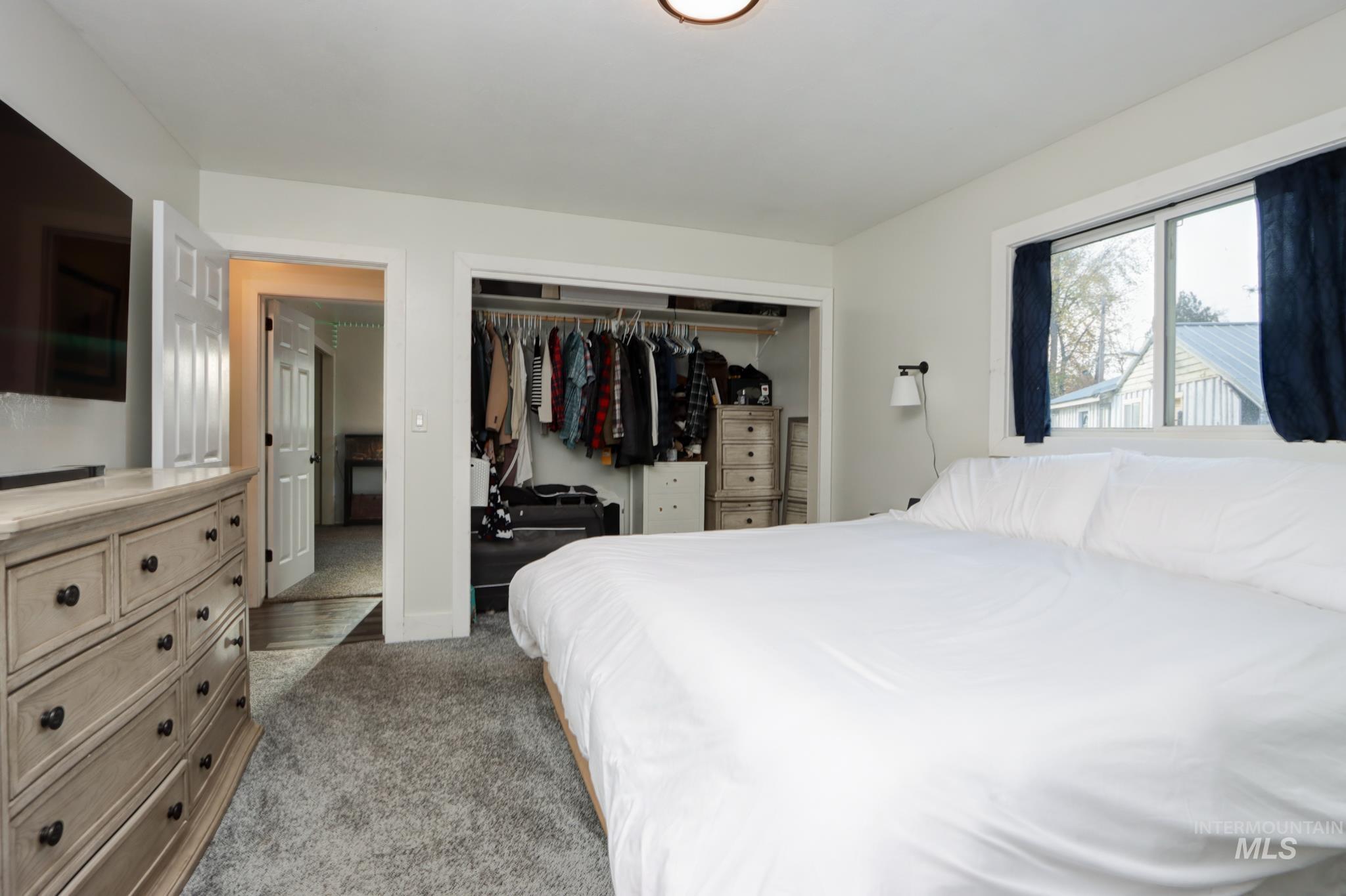 Bedroom with light carpet and a closet