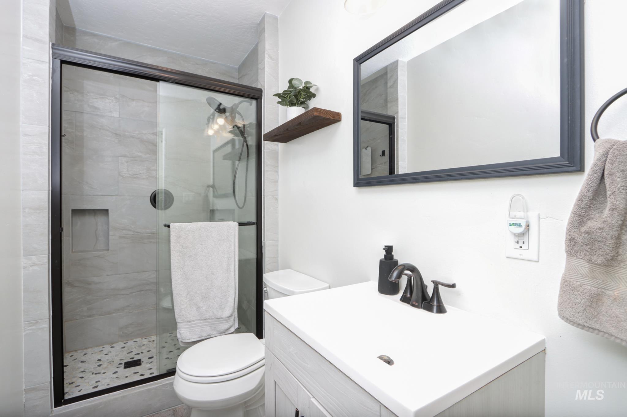 Bathroom featuring a shower stall and vanity