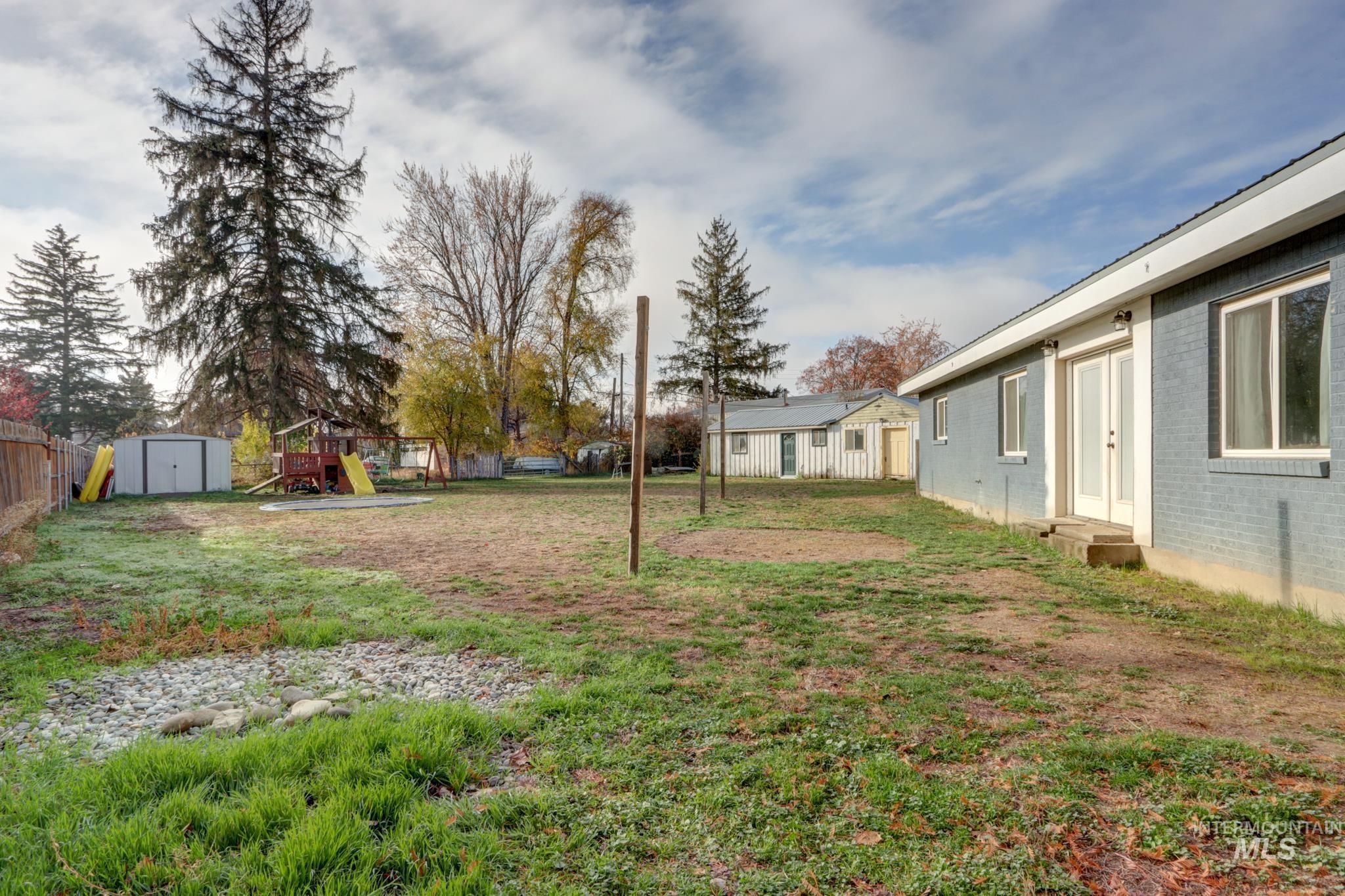 View of yard with a playground, a storage unit, and entry steps