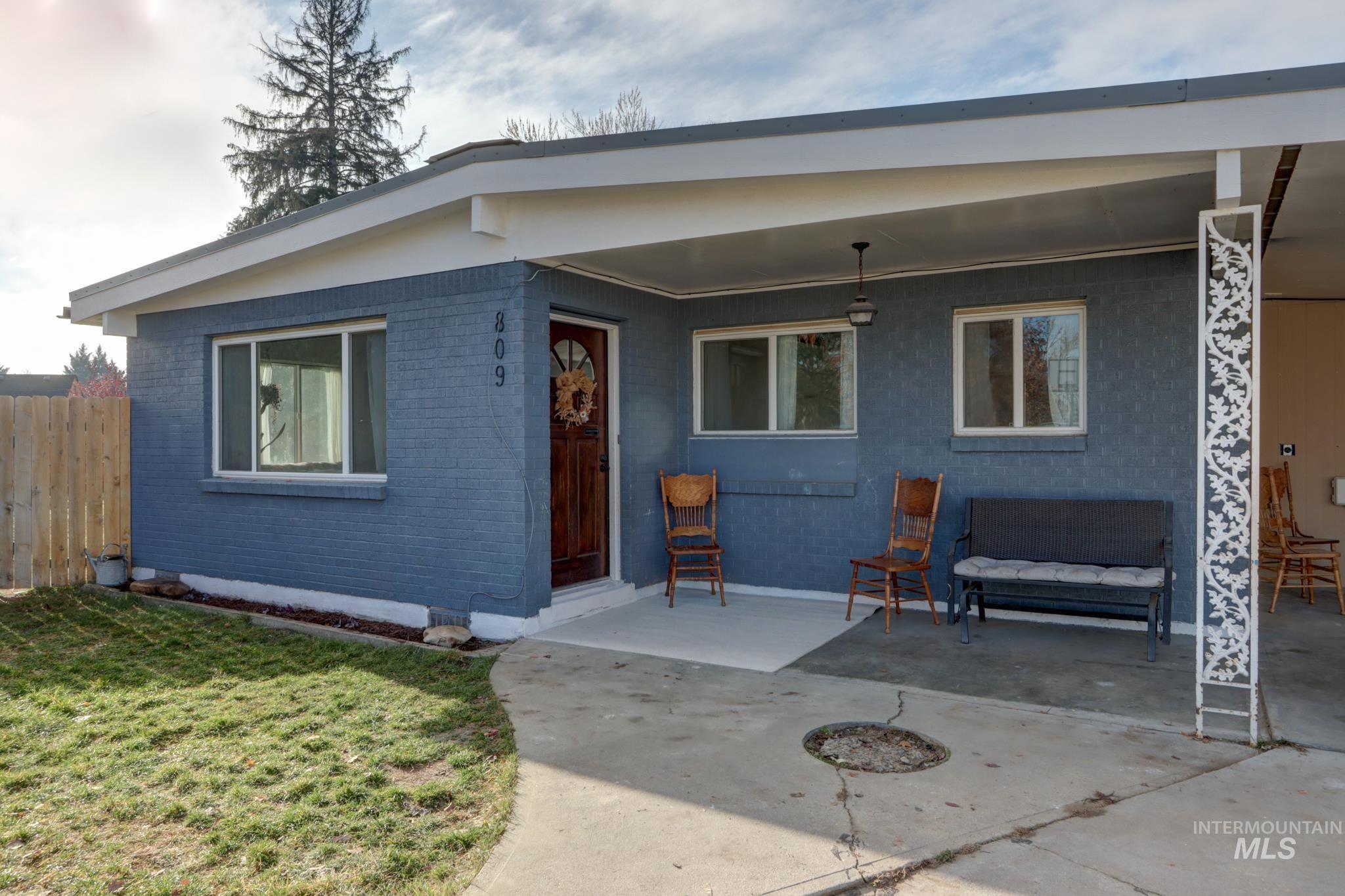 View of front of property featuring brick siding and a patio area