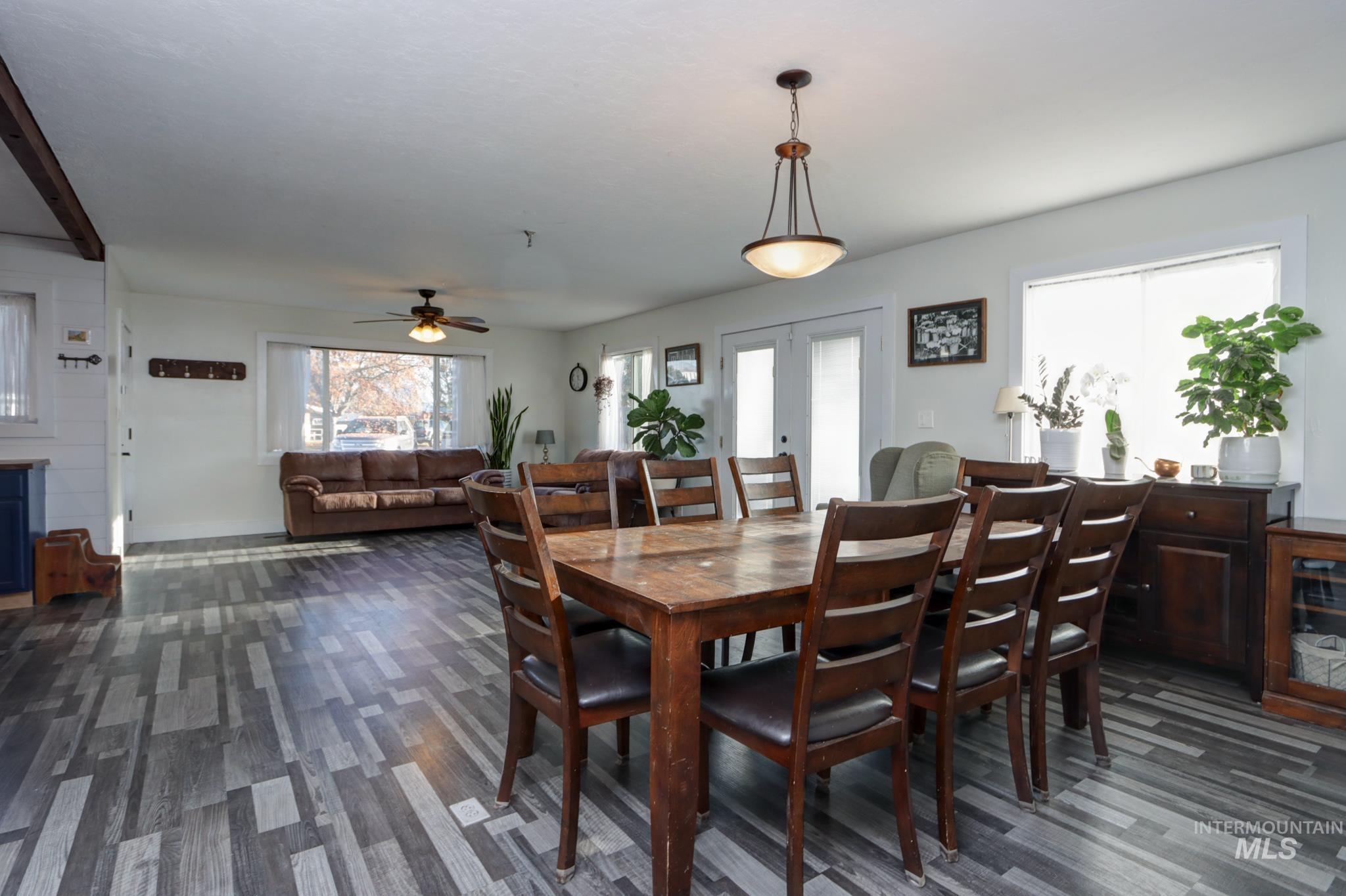 Dining space with a ceiling fan, french doors, and dark wood-type flooring