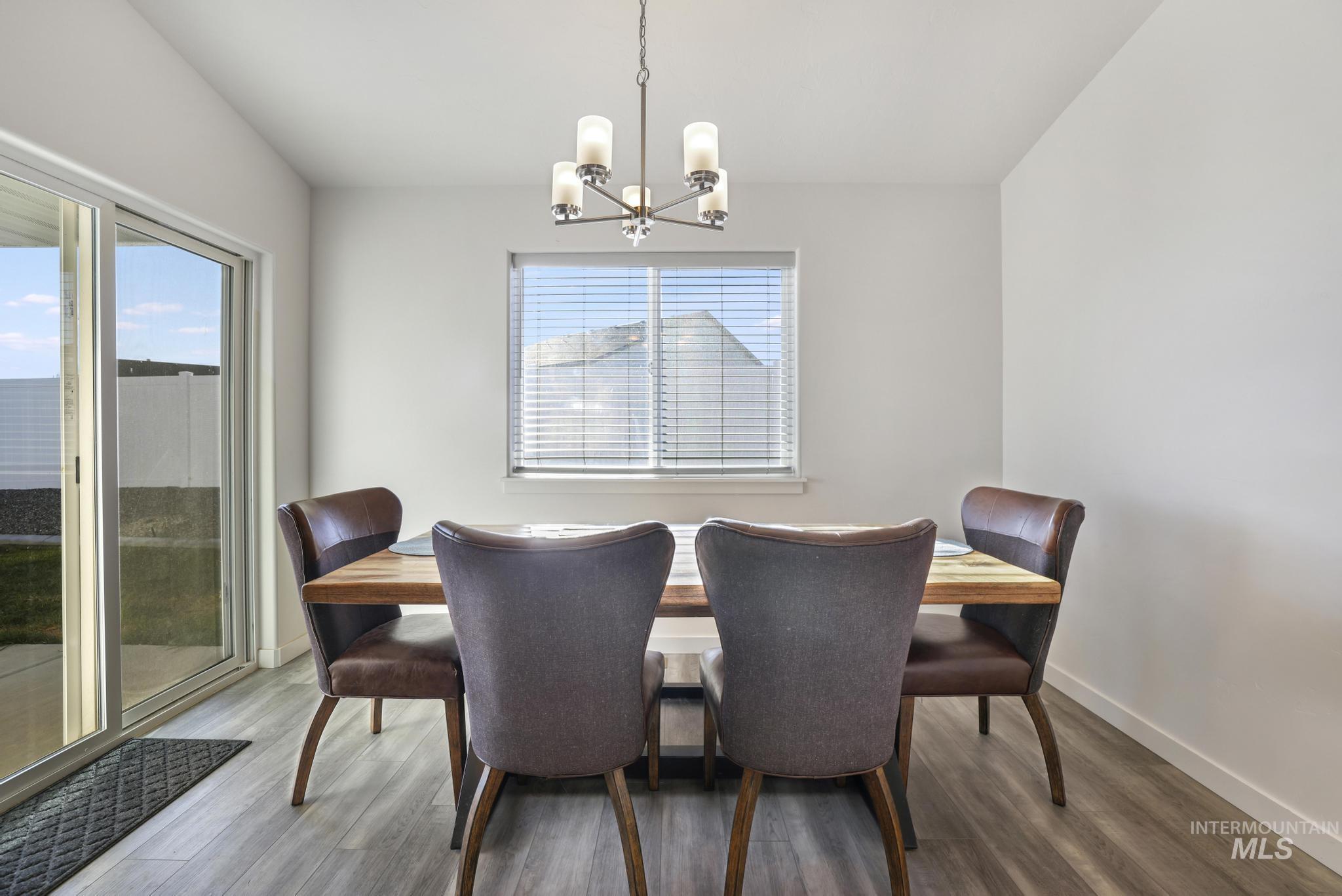 Dining area with wood finished floors, a chandelier, and plenty of natural light