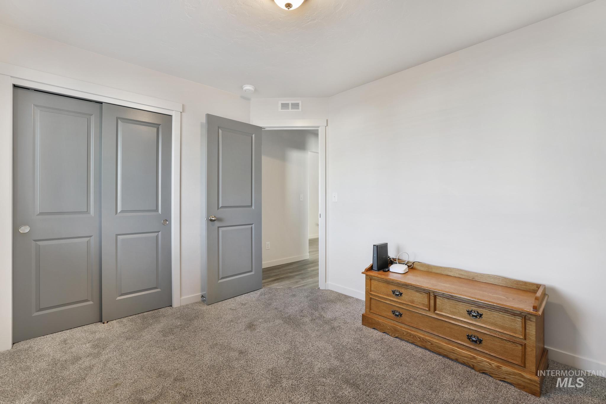 Carpeted bedroom featuring a closet and baseboards