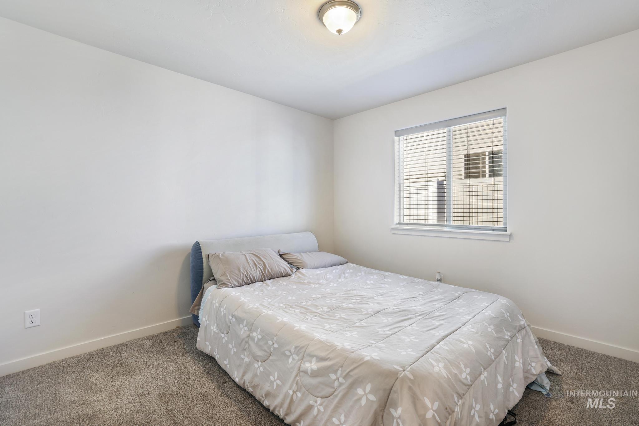 Carpeted bedroom featuring baseboards