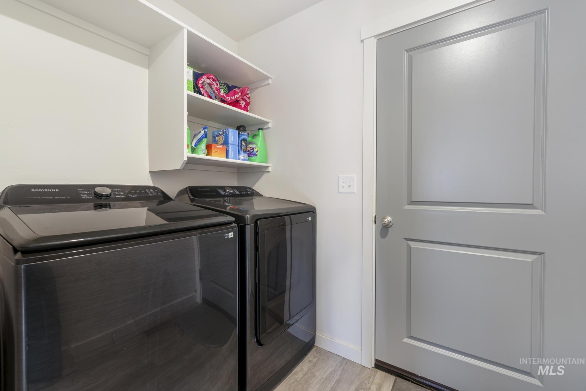 Laundry area featuring independent washer and dryer and light wood-style flooring