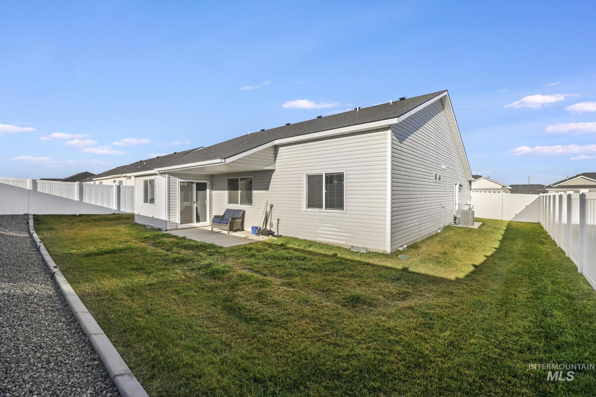 Rear view of property with a patio and a fenced backyard