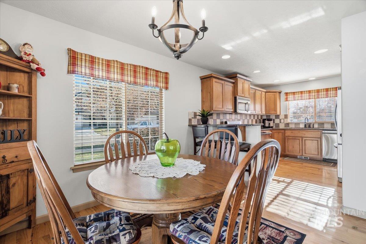 Dining area featuring a chandelier, light wood-style flooring, and recessed lighting