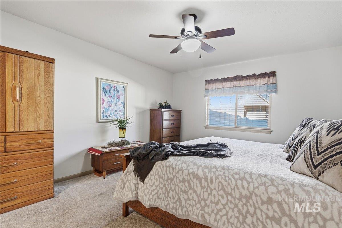 Bedroom with light carpet and a ceiling fan