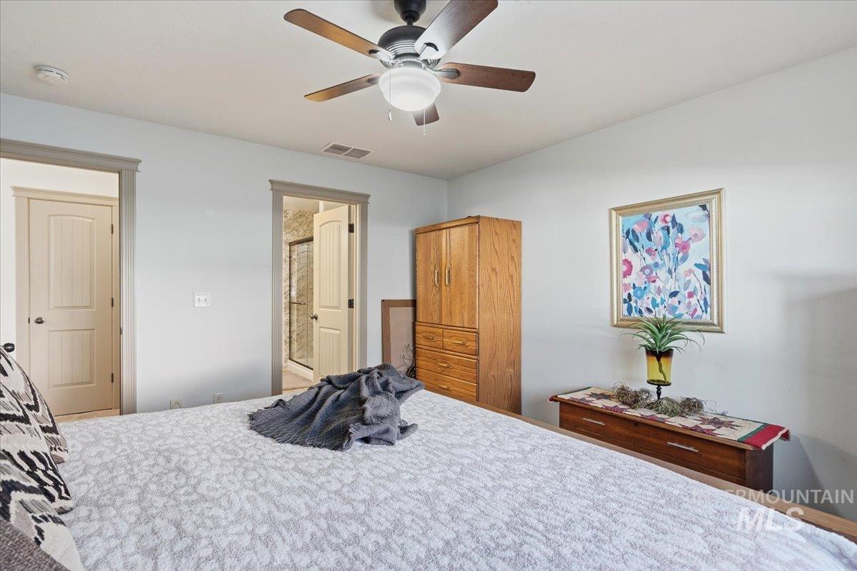 Bedroom featuring a ceiling fan and ensuite bathroom
