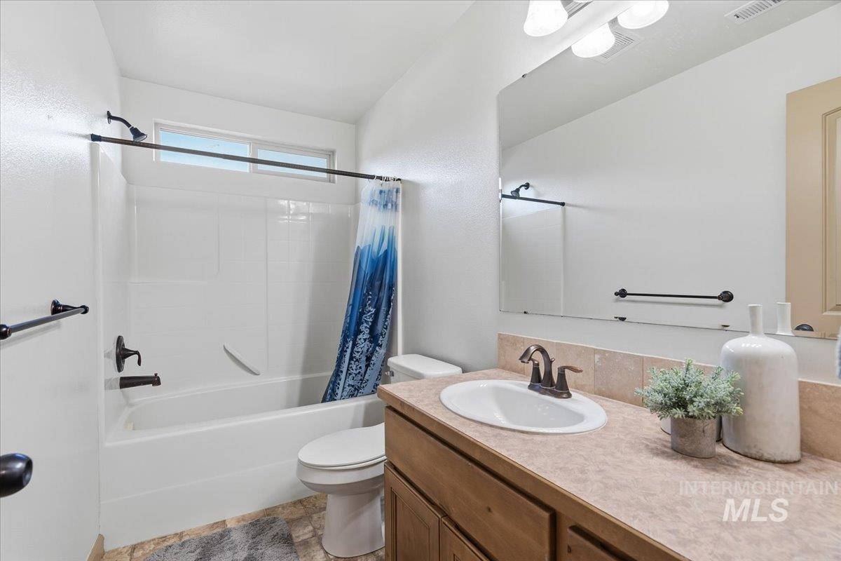 Bathroom with shower / bathtub combination with curtain and vanity
