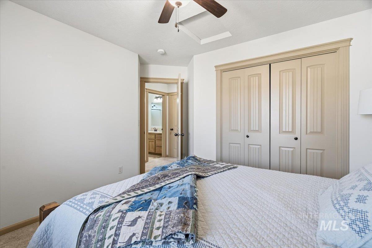 Bedroom featuring carpet, ceiling fan, and a closet