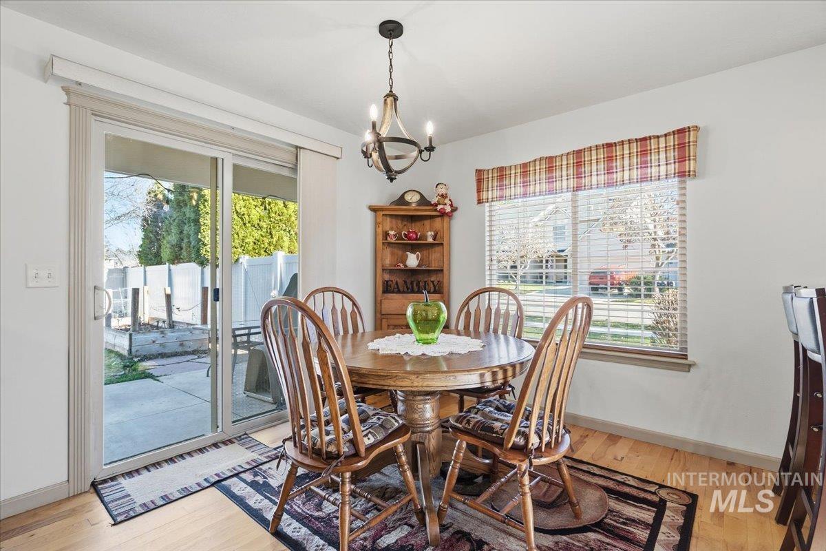 Dining room with a chandelier, healthy amount of natural light, and light wood-style flooring