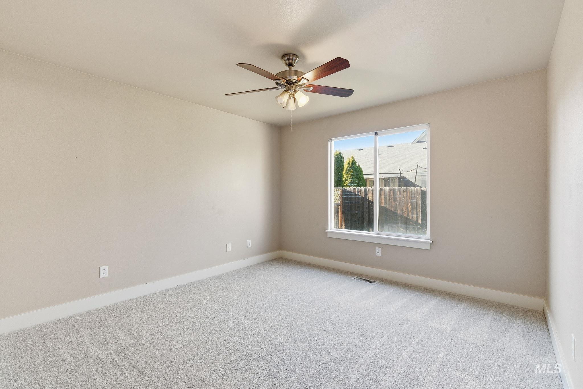 Spare room featuring carpet floors and ceiling fan
