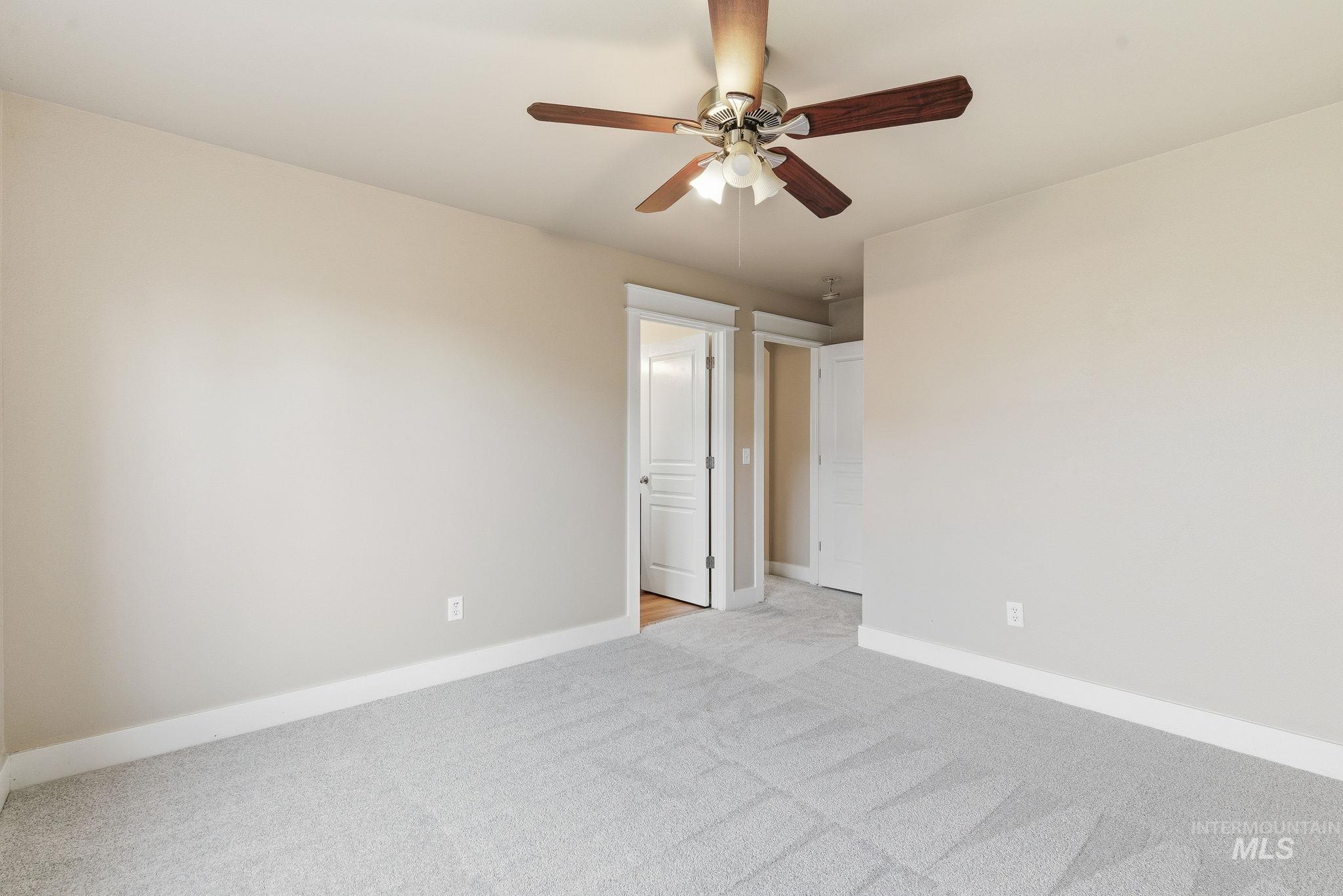 Unfurnished room with light colored carpet and ceiling fan