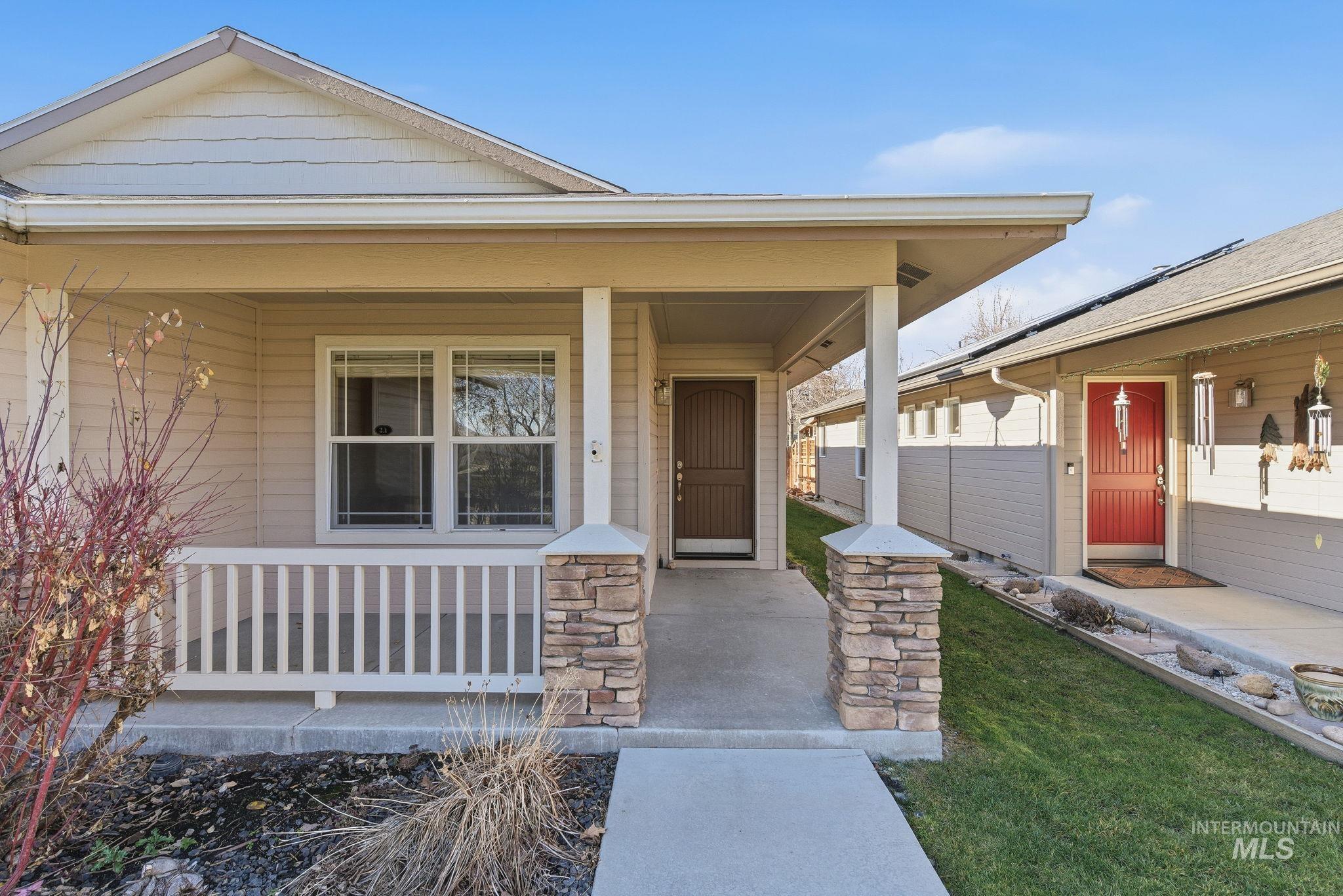 View of exterior entry featuring a porch and stone siding