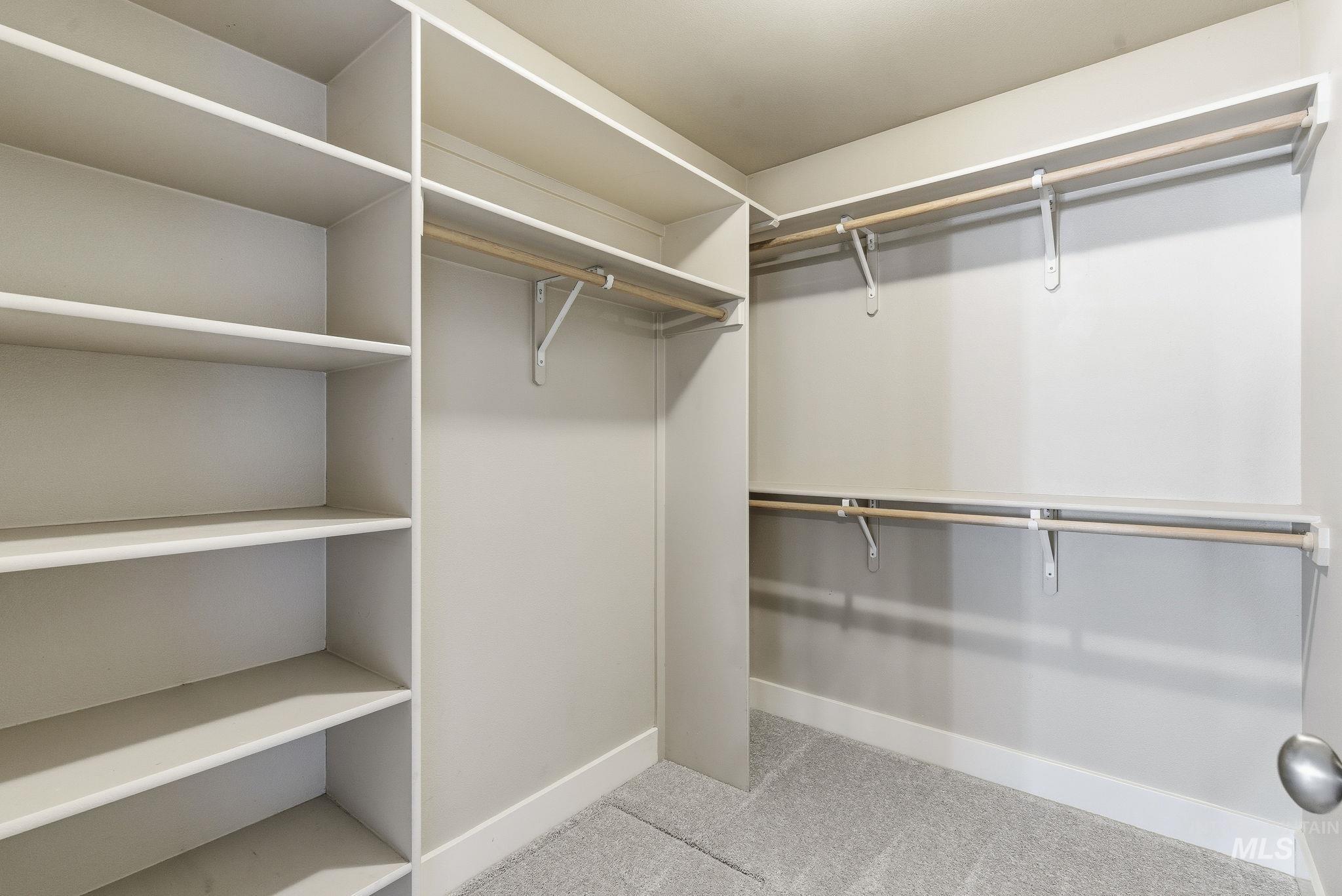 Spacious closet with light colored carpet