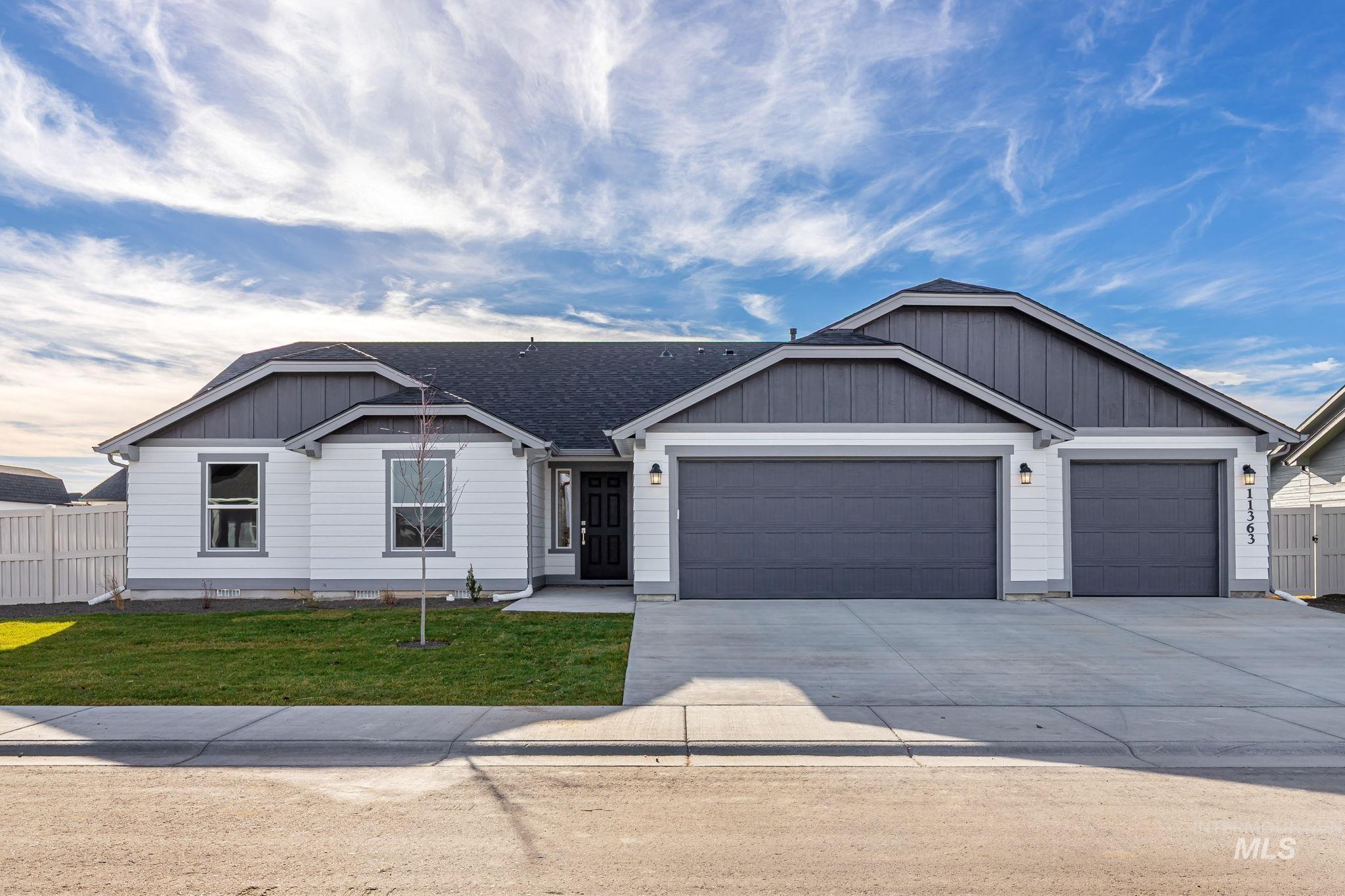 View of front of house with driveway, a garage, and roof with shingles
