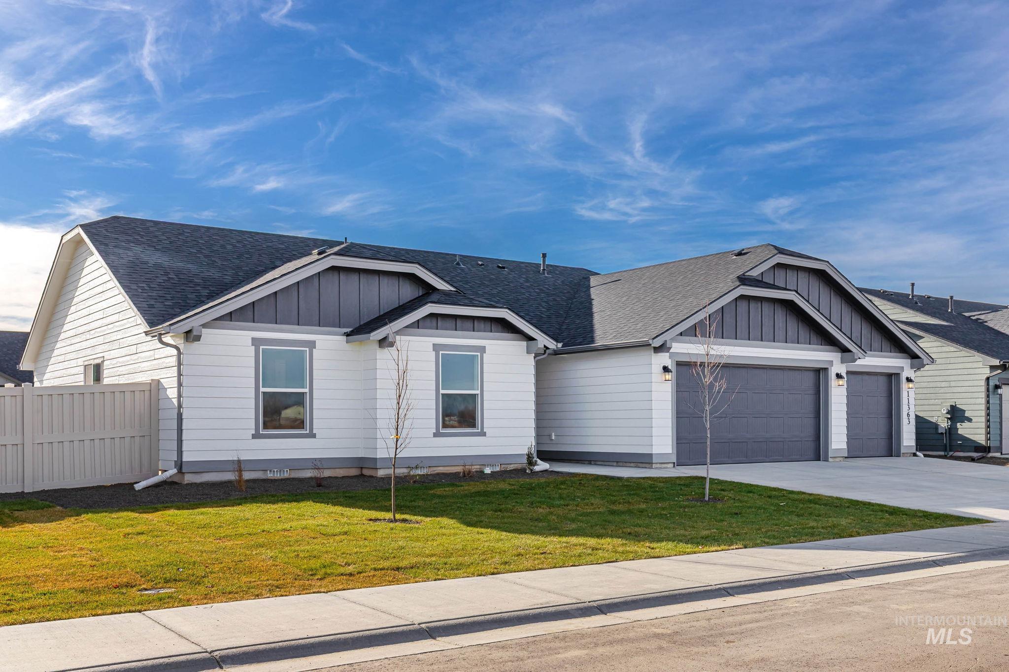 View of front of home with roof with shingles, board and batten siding, concrete driveway, and a garage