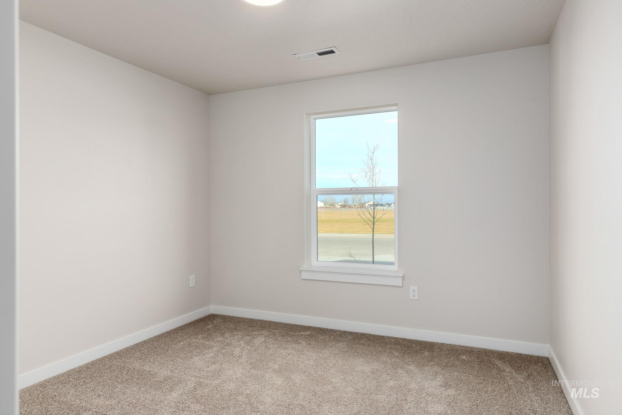 Carpeted empty room with baseboards