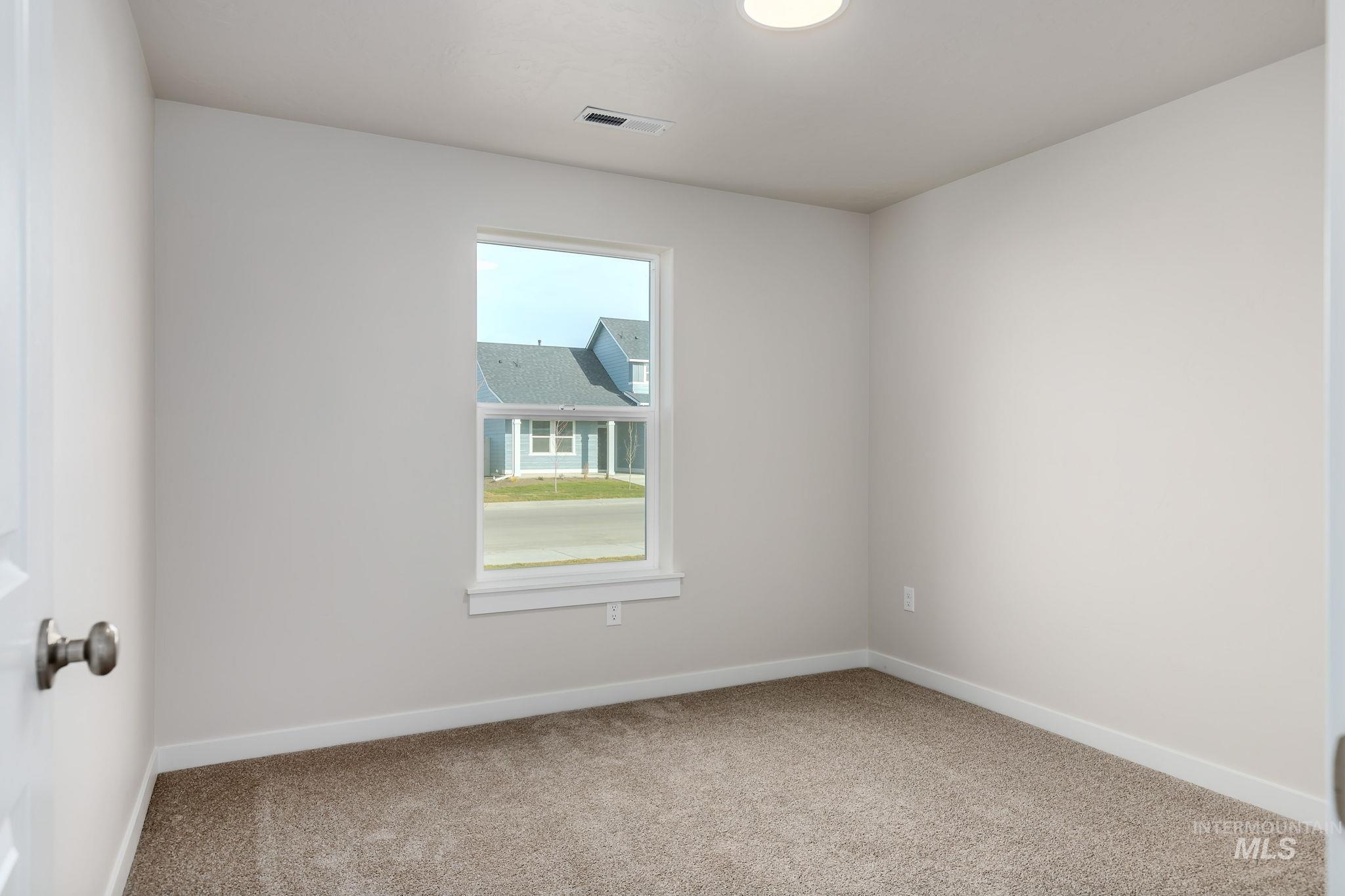 Spare room featuring baseboards and carpet floors