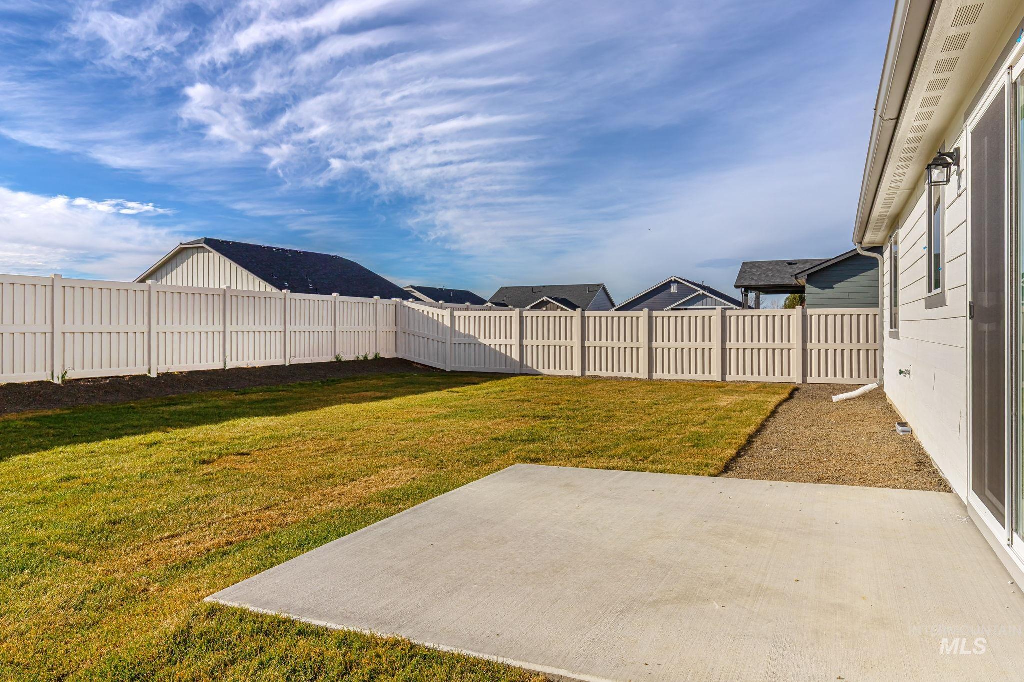 Fenced backyard with a patio area and a residential view
