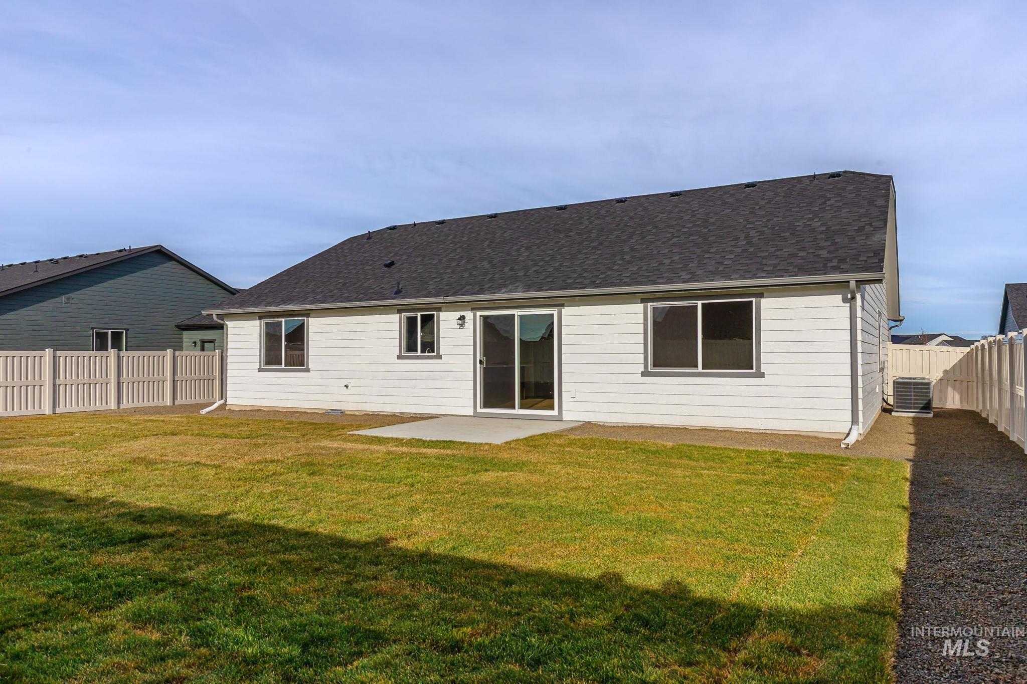 Back of house with a patio area, a fenced backyard, and roof with shingles