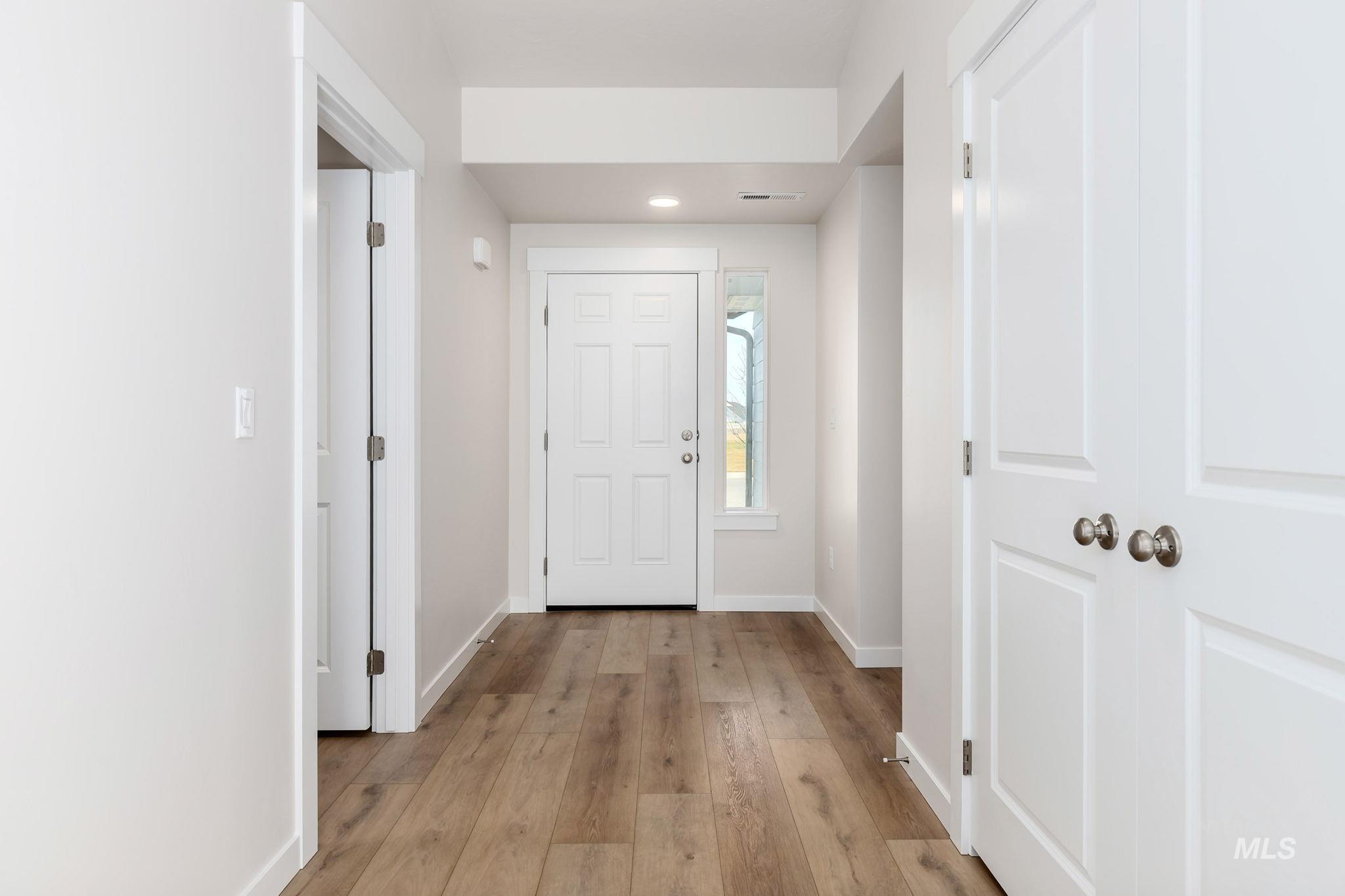 Foyer with light wood-style floors and recessed lighting