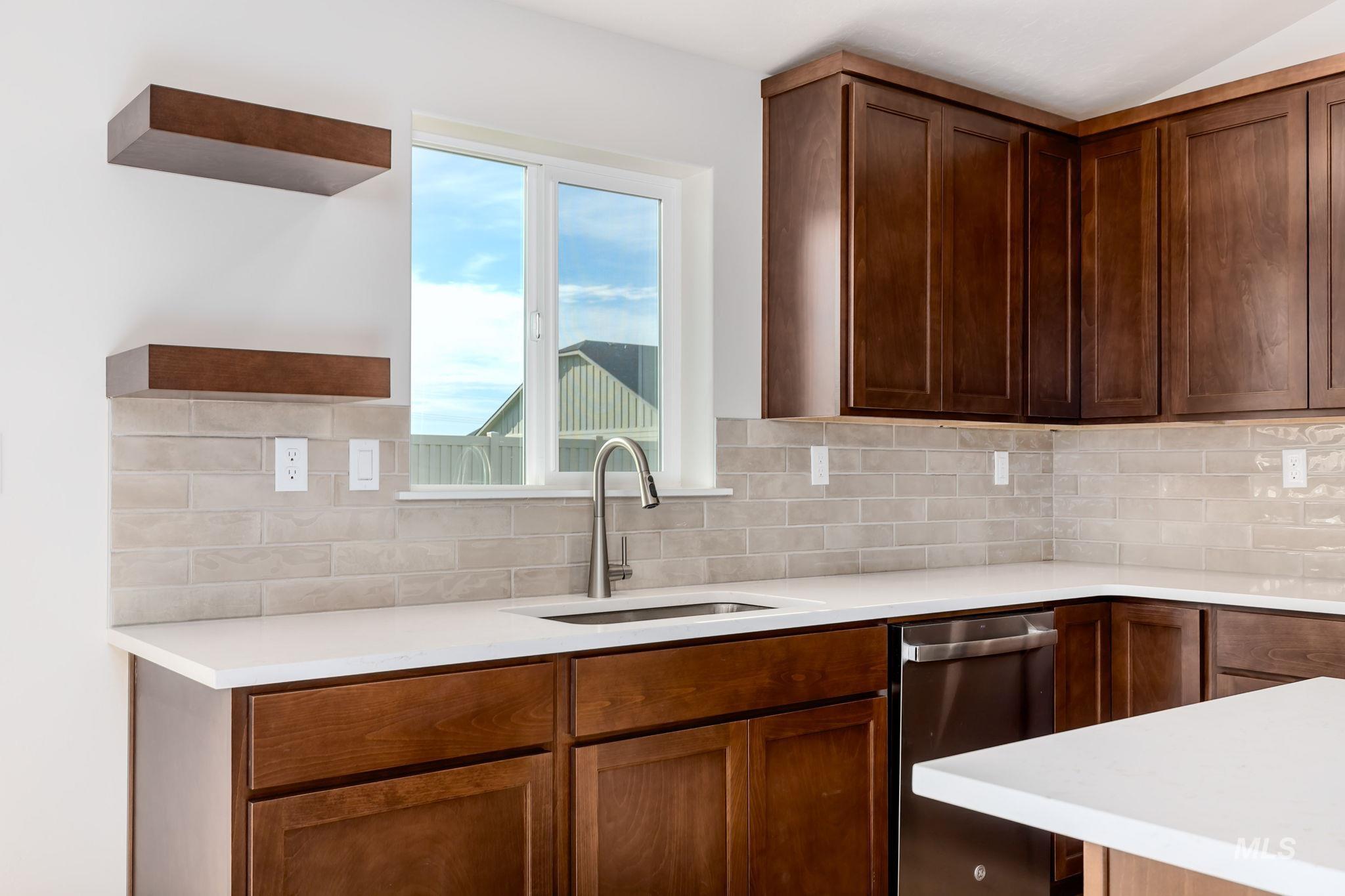 Kitchen with open shelves, light stone countertops, stainless steel dishwasher, and backsplash