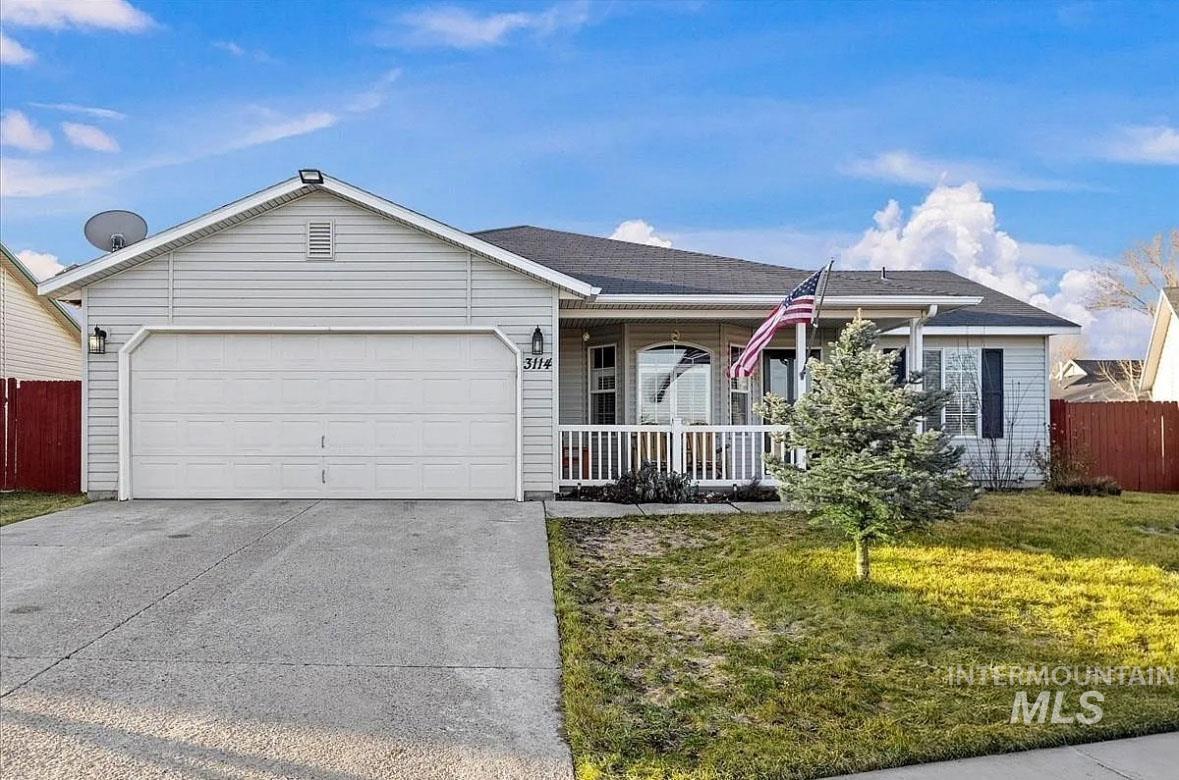 Ranch-style house featuring a porch, driveway, and a garage