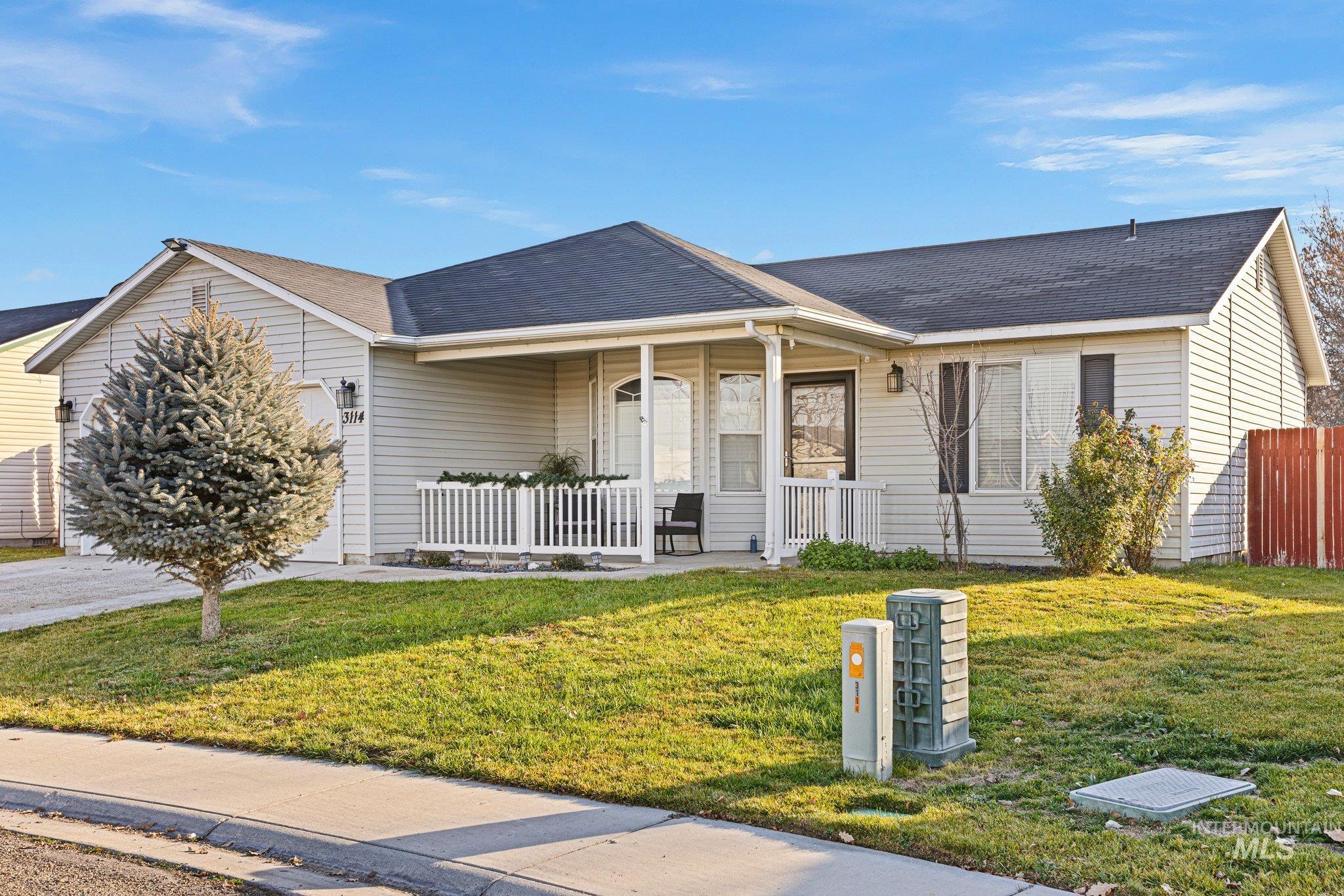 Single story home with covered porch, a garage, and roof with shingles