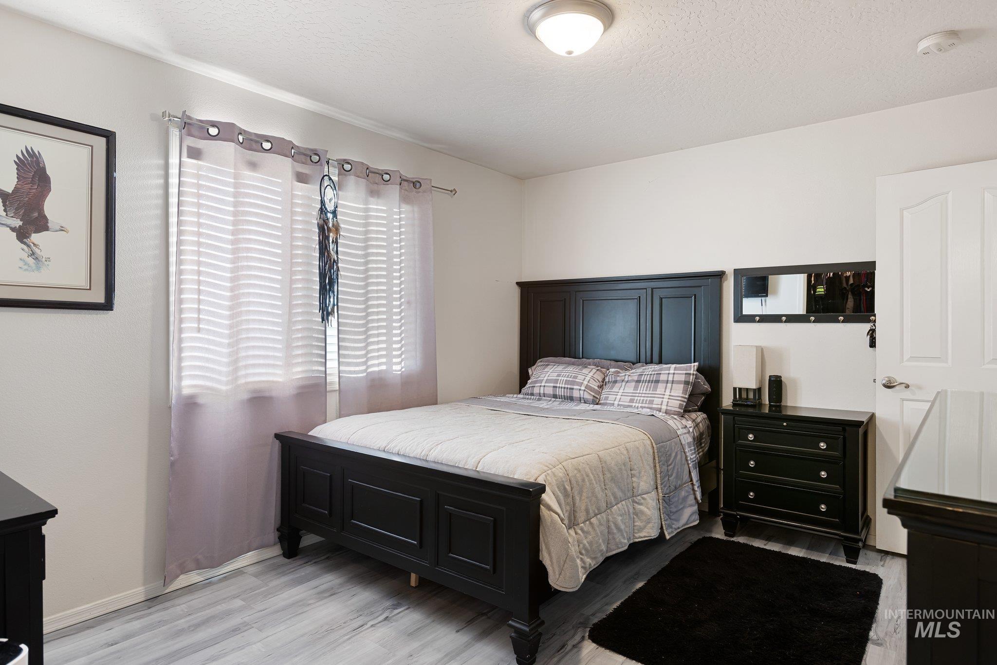 Bedroom with a textured ceiling and light wood-style flooring