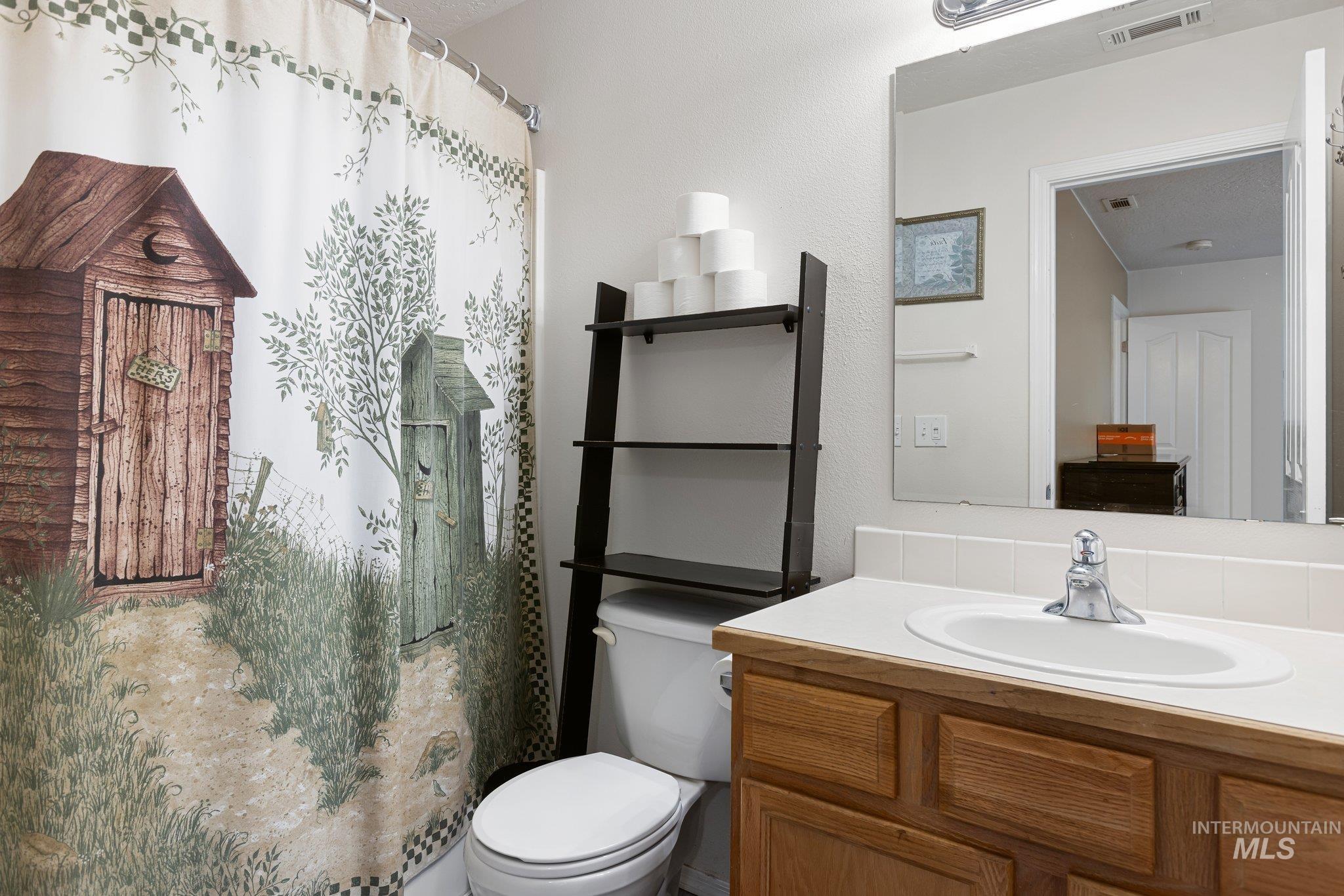 Bathroom featuring a shower with shower curtain and vanity