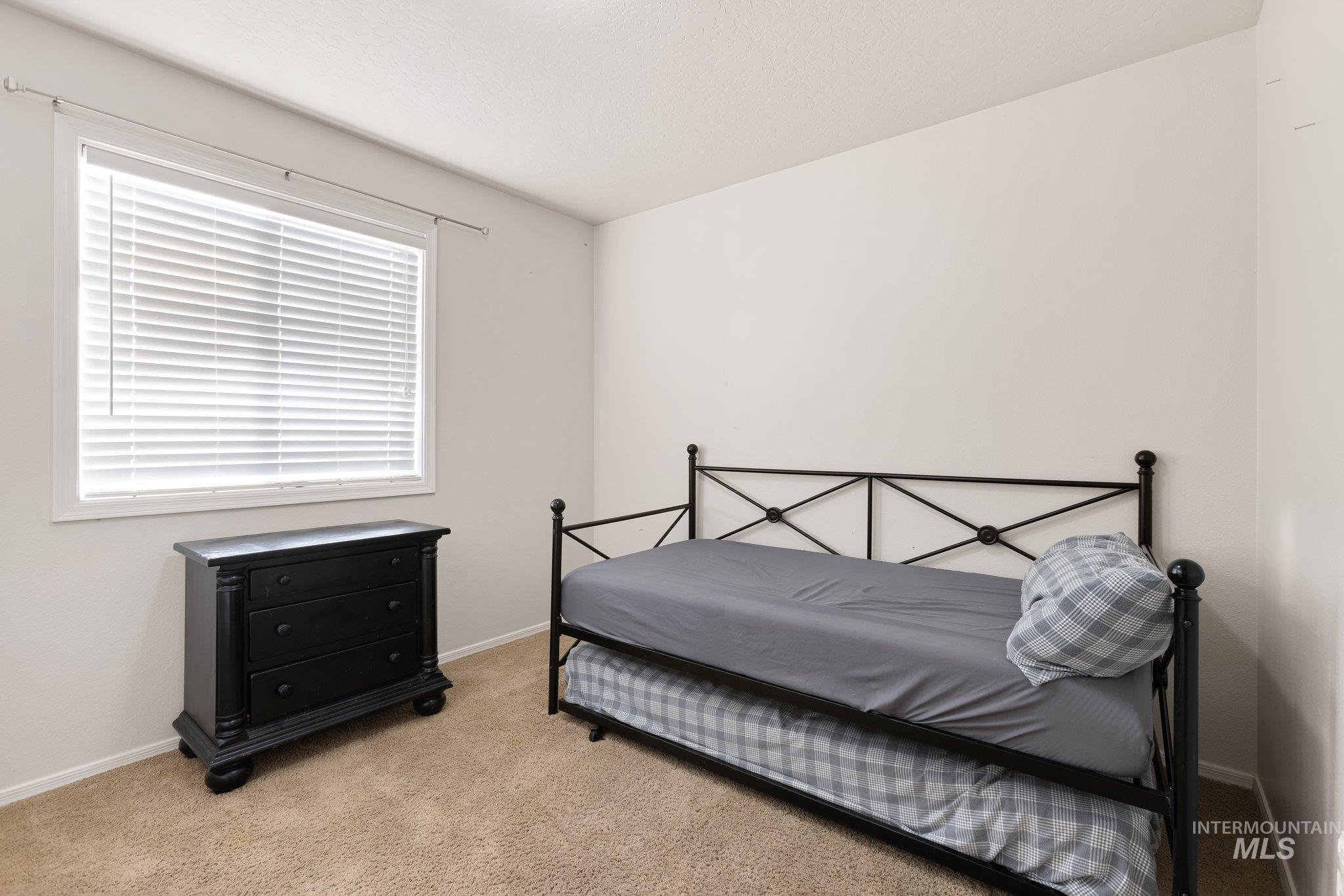 Bedroom featuring light carpet and baseboards