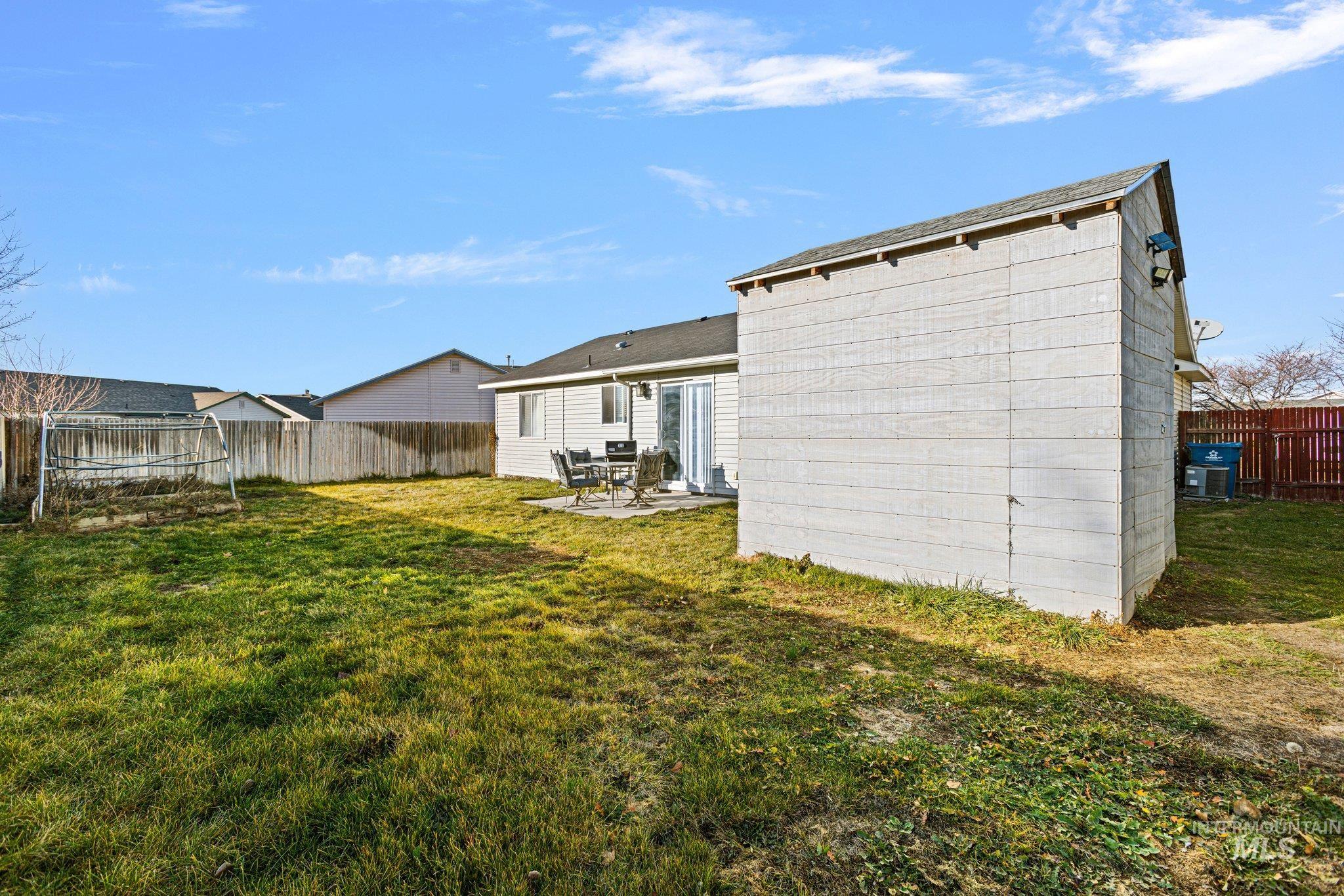 Rear view of house with a fenced backyard, a patio area, and a trampoline