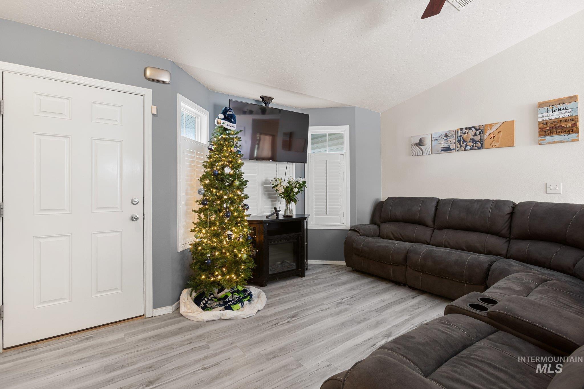 Living area featuring wood finished floors, a textured ceiling, and a ceiling fan