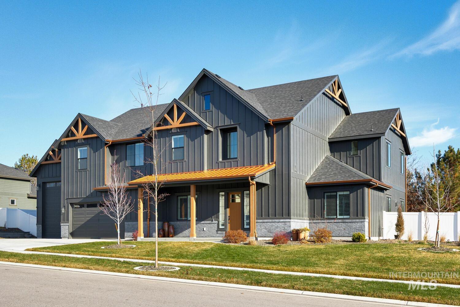 Modern inspired farmhouse featuring a porch, a shingled roof, board and batten siding, and brick siding