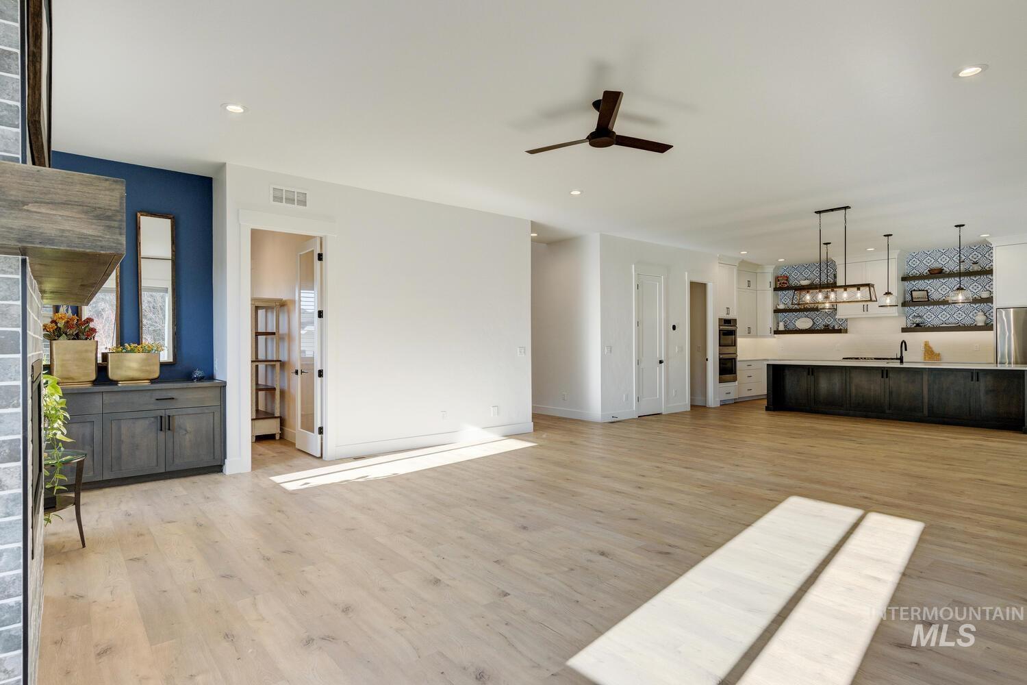 Unfurnished living room with light wood finished floors, ceiling fan, and recessed lighting