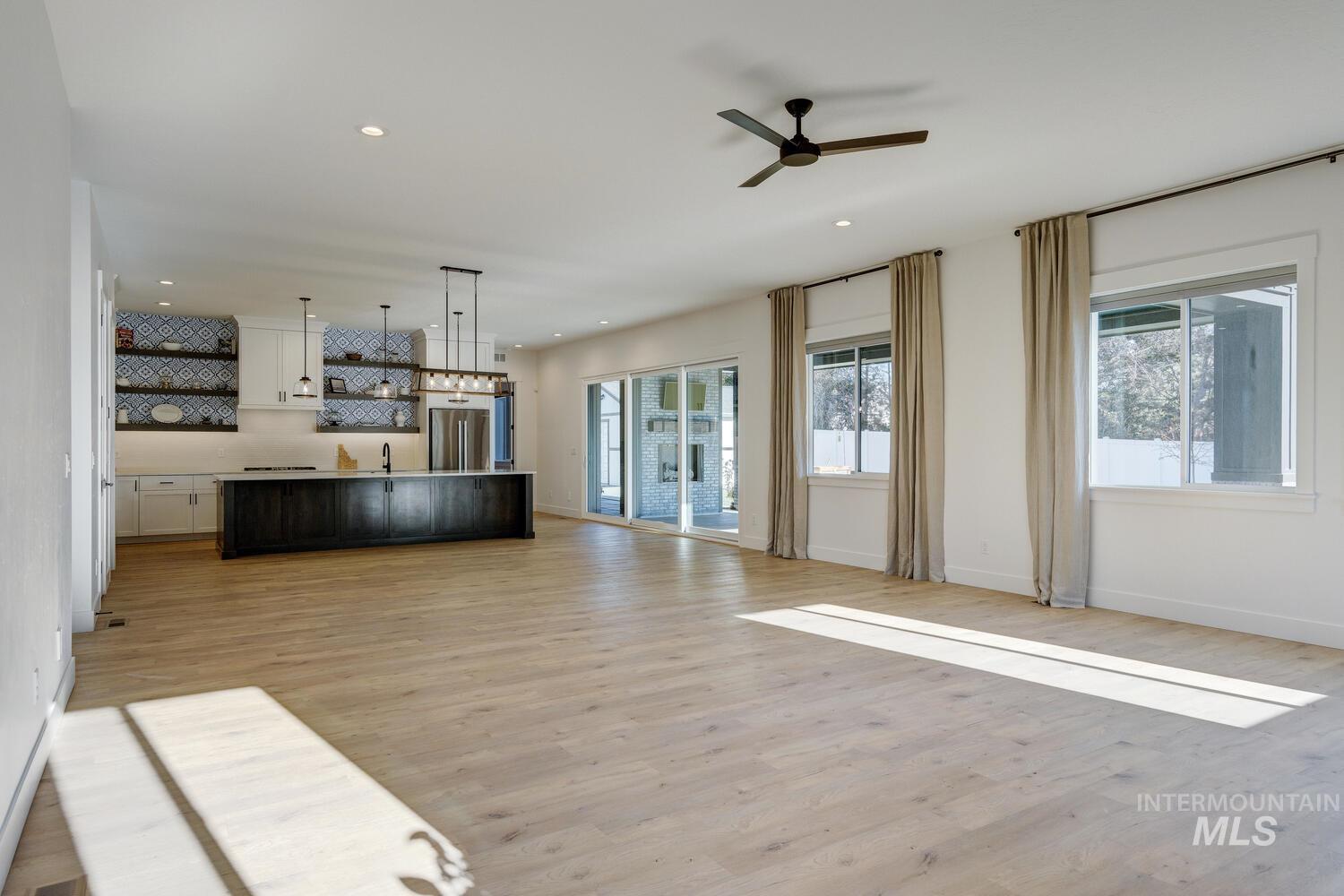Unfurnished living room with light wood-style flooring, recessed lighting, and a ceiling fan
