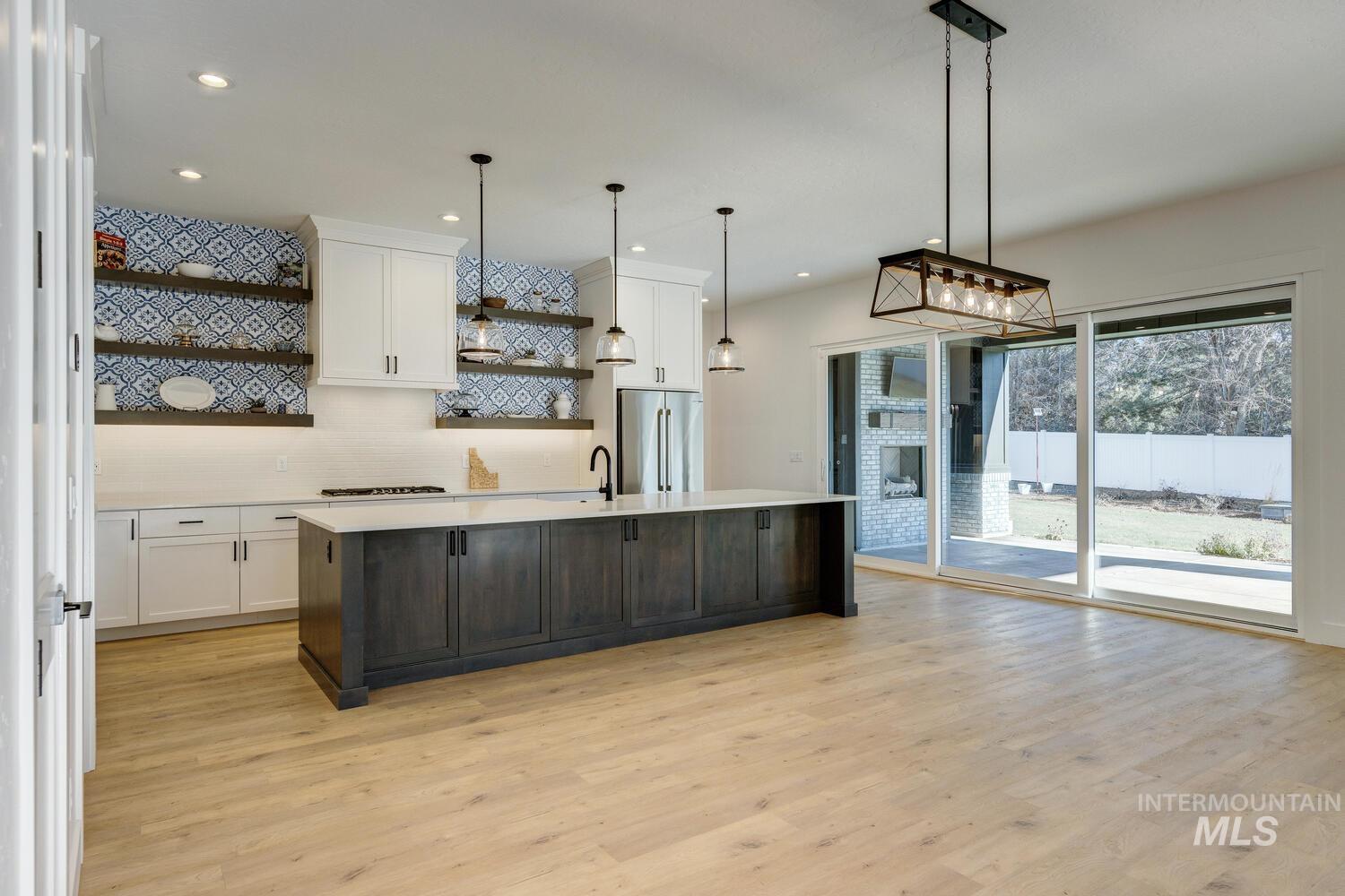 Kitchen with open shelves, white cabinets, pendant lighting, a kitchen island with sink, and recessed lighting