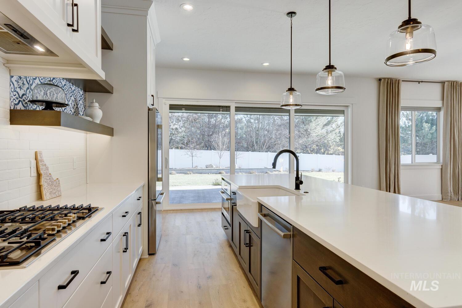 Kitchen with white cabinets, tasteful backsplash, stainless steel appliances, pendant lighting, and recessed lighting