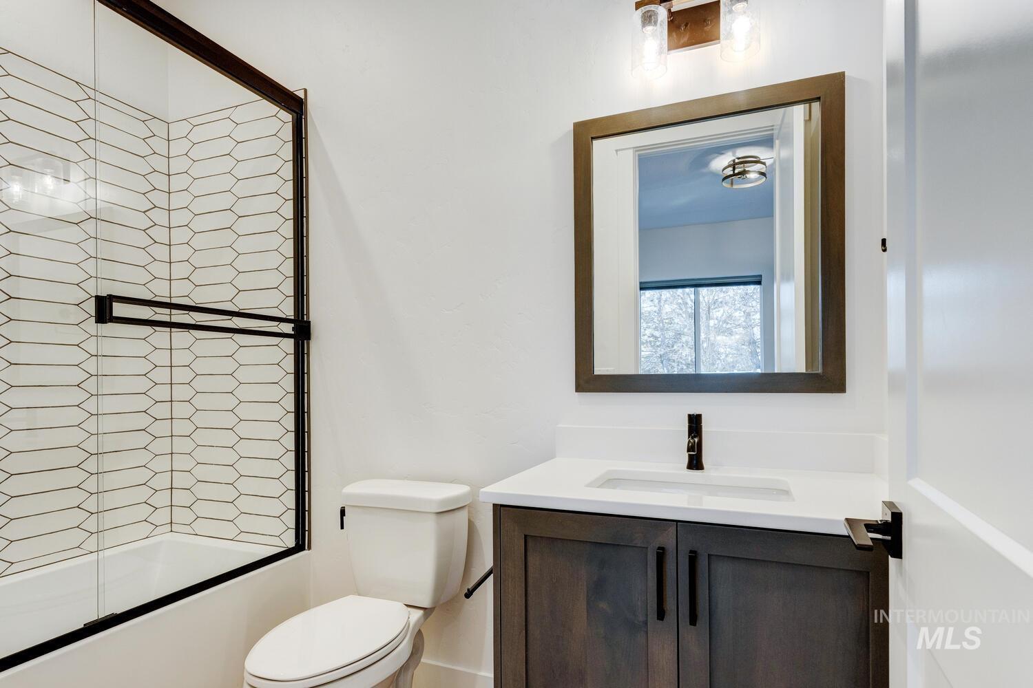 Full bathroom featuring vanity and bath / shower combo with glass door