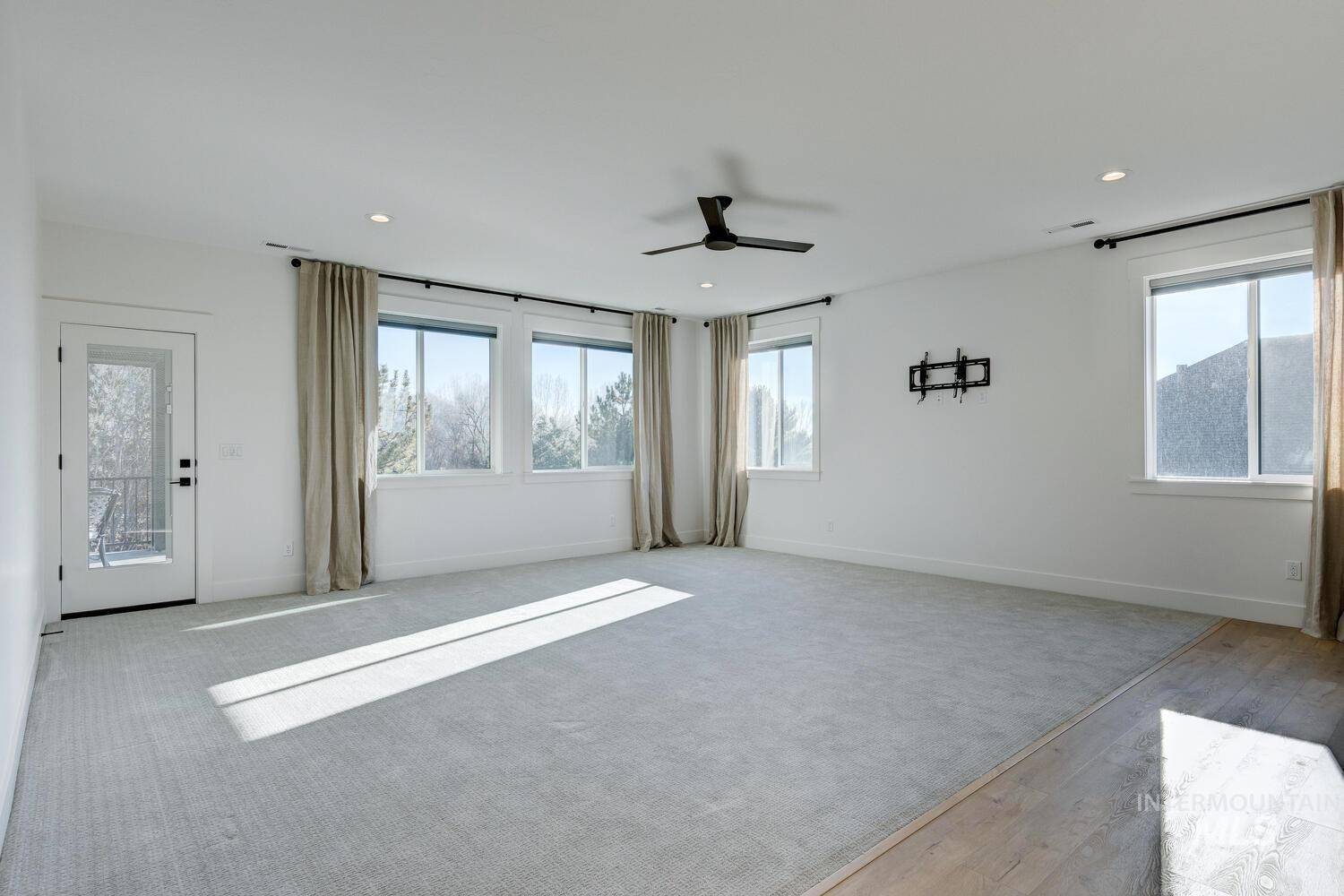 Empty room featuring healthy amount of natural light, recessed lighting, a ceiling fan, and light carpet