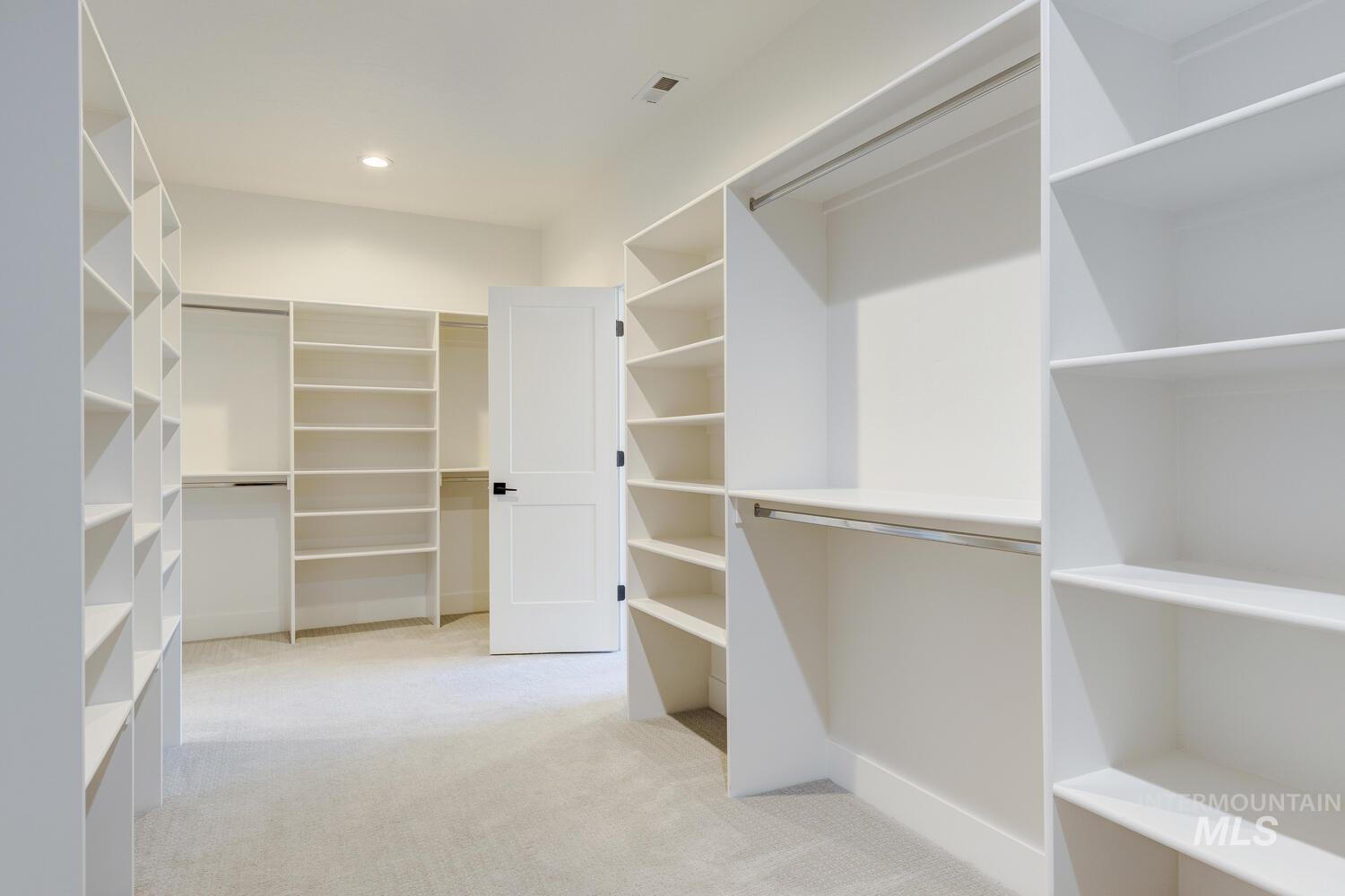 Walk in closet featuring light carpet