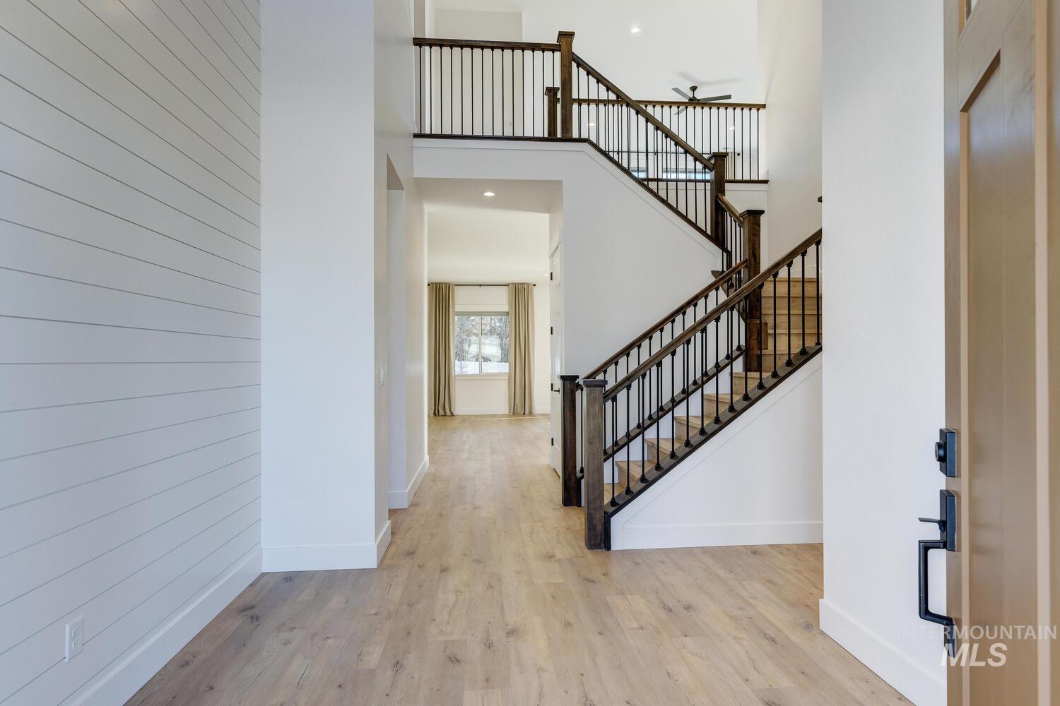 Foyer featuring a towering ceiling, wood finished floors, and stairway