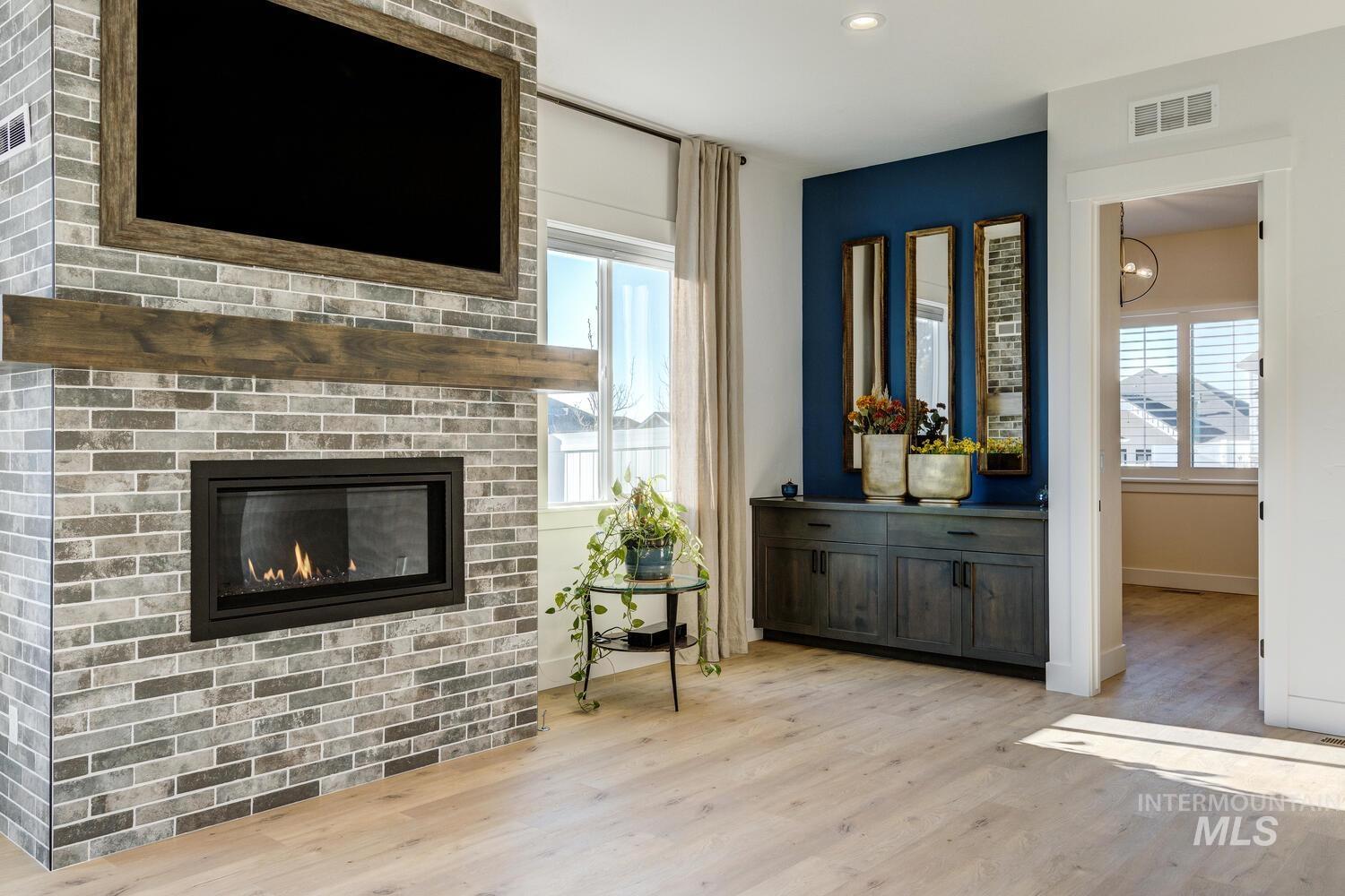 Living area with light wood-style floors, a fireplace, and recessed lighting