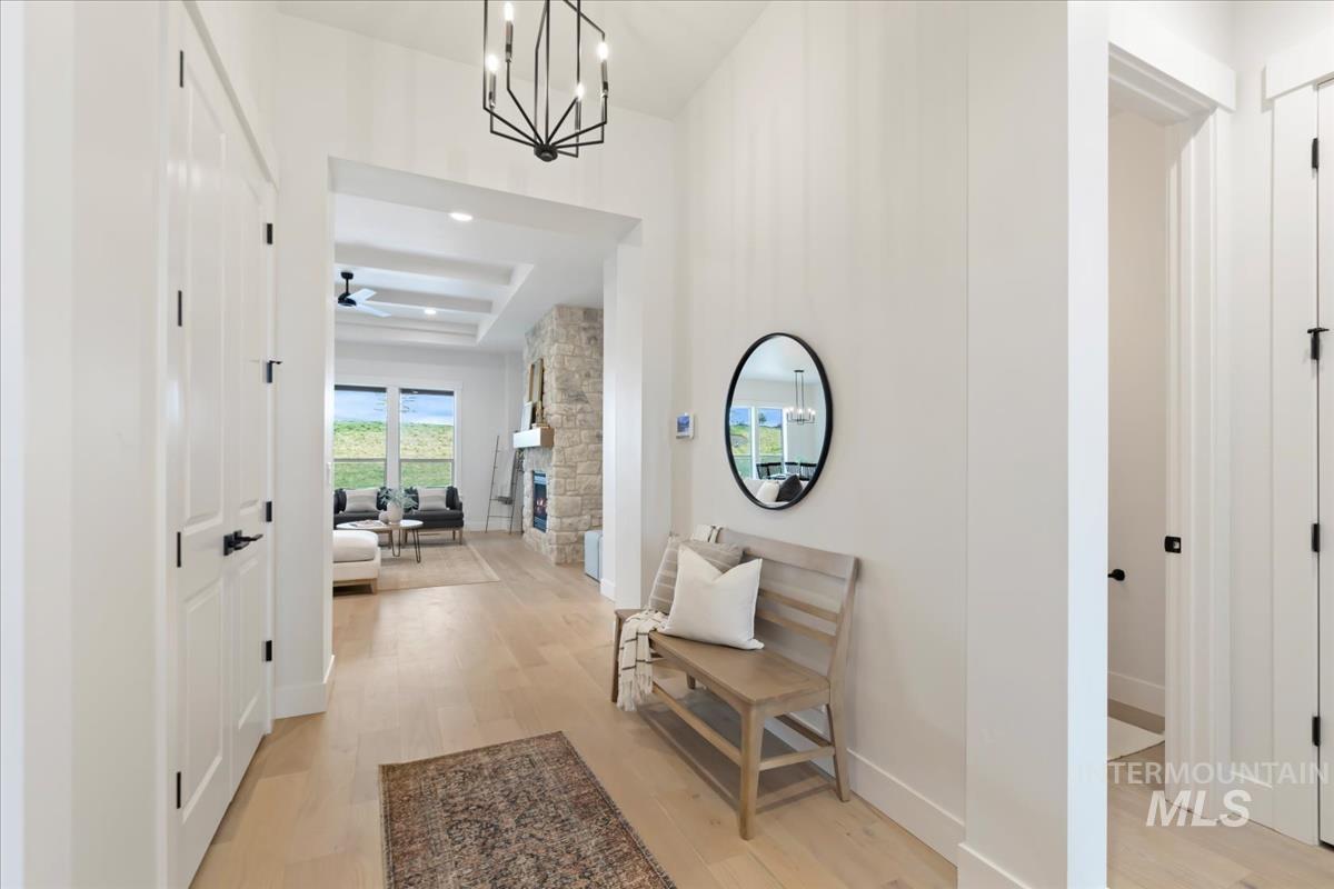 Corridor featuring light wood-style flooring and a chandelier
