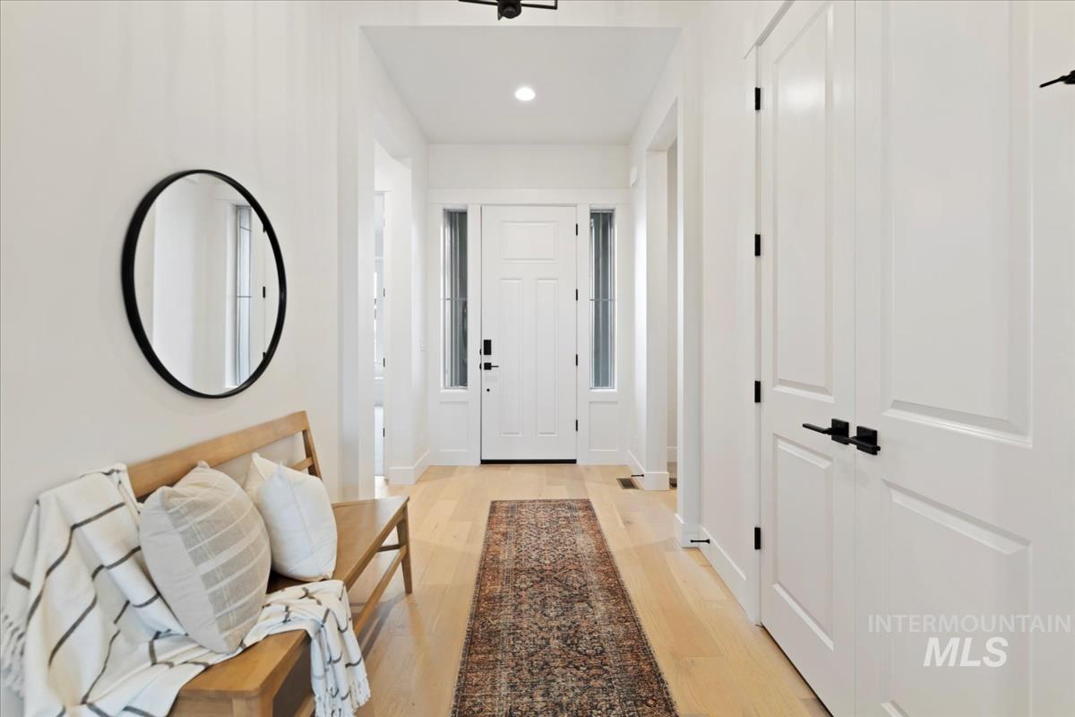 Hall with light wood-type flooring and recessed lighting