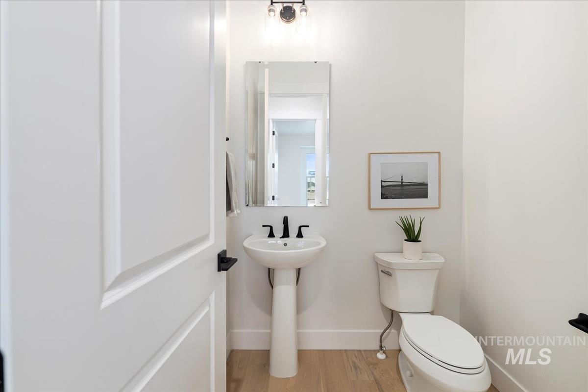 Half bathroom with toilet and light wood-style floors
